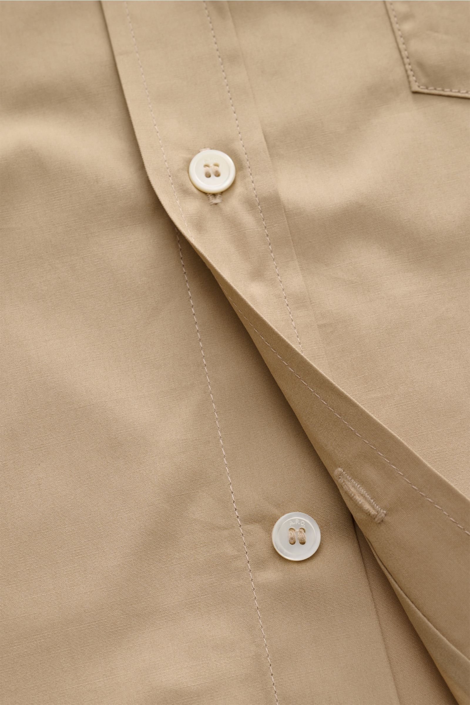 A close-up front view of the A.P.C. Casual shirt Kent collar sand, showcasing the patch button placket, smooth pure cotton fabric, and fine stitching. A modern take on a classic look: This shirt by A.P.C. has a timeless aesthetic. It works as well in styl