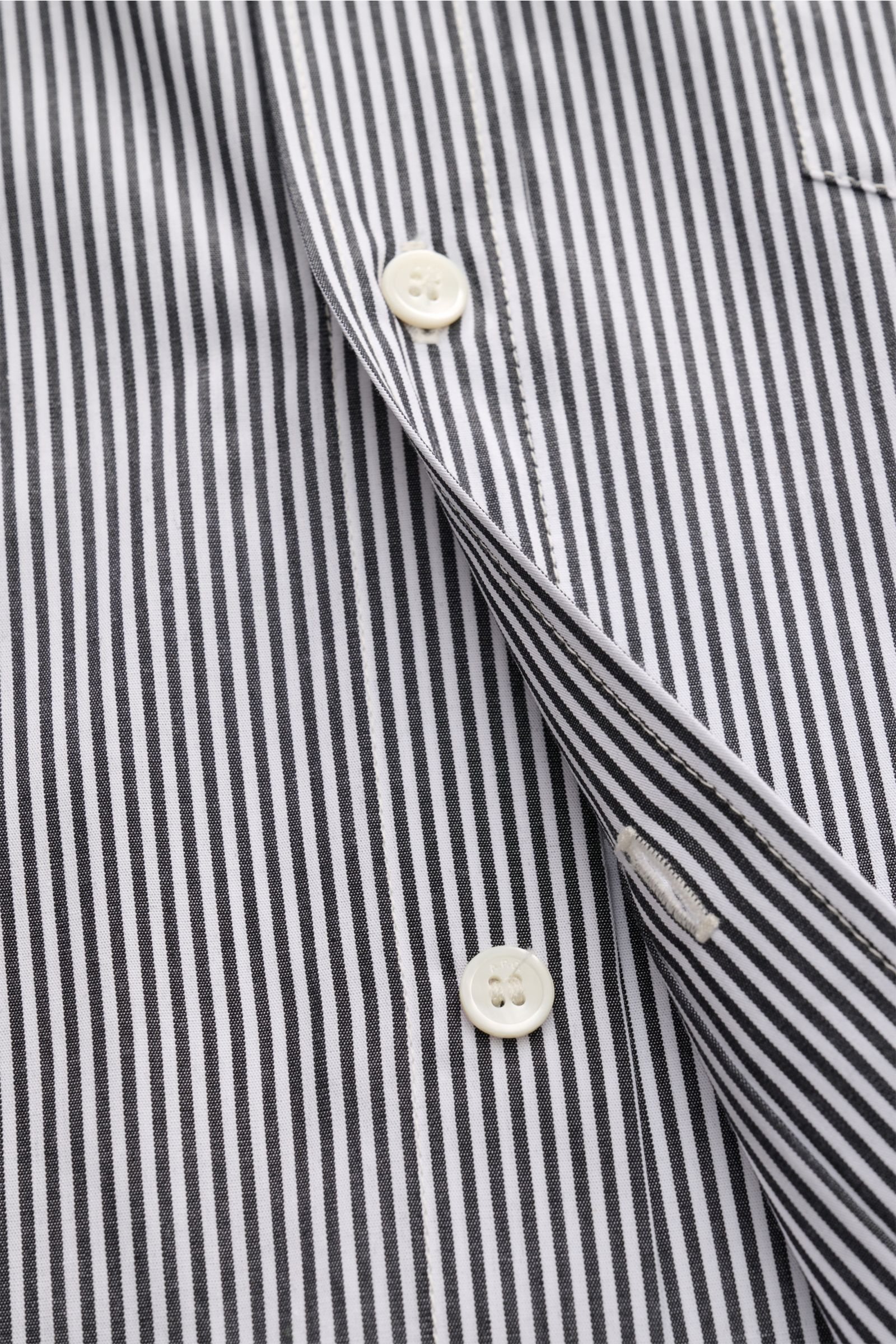 Close-up front view of A.P.C. Casual Hemd Kent-Kragen schwarz/weiß gestreift showing white buttons on black and white striped pure cotton fabric with smooth texture, oversized fit, Kent collar, classic sport cuffs, chest pocket, and slightly rounded hem.