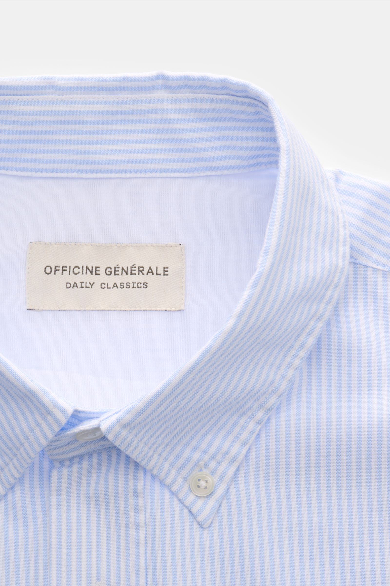 Close-up front view of Officine Générale Oxford-Hemd Button-Down-Kragen weiß/hellblau gestreift with button-down collar and label inside collar.

Zeitloses Essential: Das Oxford-Hemd von OFFICINE GÉNÉRALE überzeugt mit seinem klassischen Design und wir
