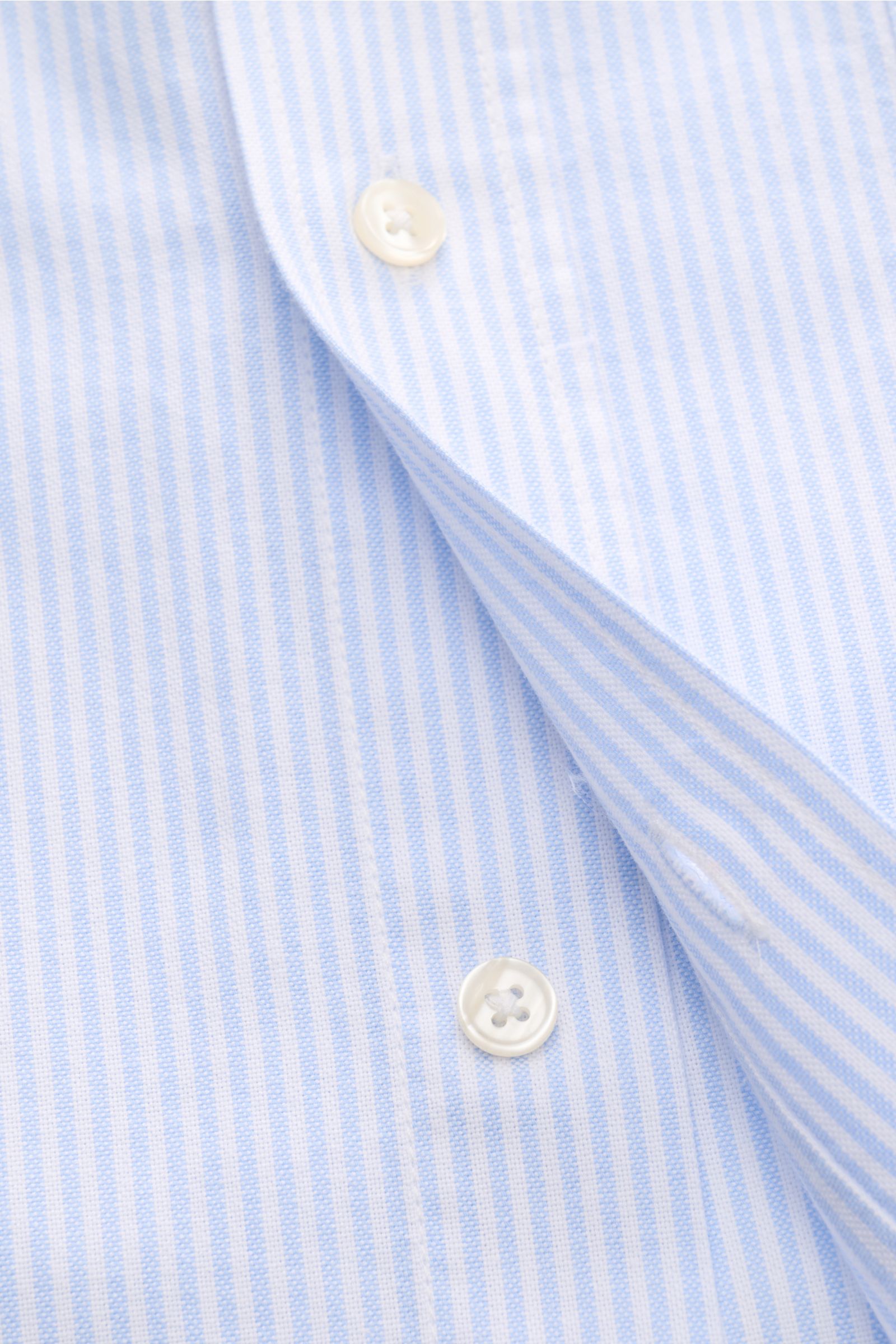 Close-up front view of Officine Générale Oxford-Hemd Button-Down-Kragen weiß/hellblau gestreift, showing soft cotton fabric, button-down collar, and classic button placket.

Zeitloses Essential: Das Oxford-Hemd von OFFICINE GÉNÉRALE überzeugt mit seine