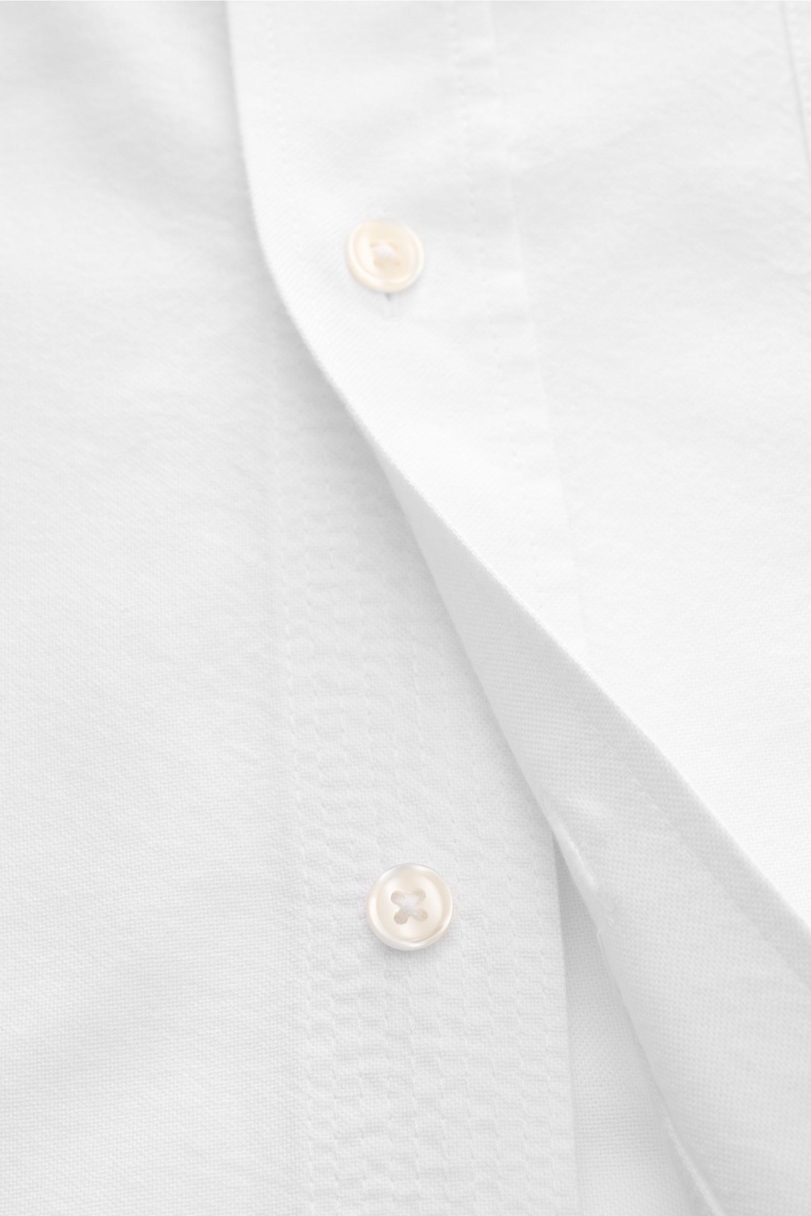Close-up front view of Officine Générale Oxford-Hemd Button-Down-Kragen weiß showing soft cotton fabric and button details, timeless essential for office and leisure.

Zeitloses Essential: Das Oxford-Hemd von OFFICINE GÉNÉRALE überzeugt mit seinem klas