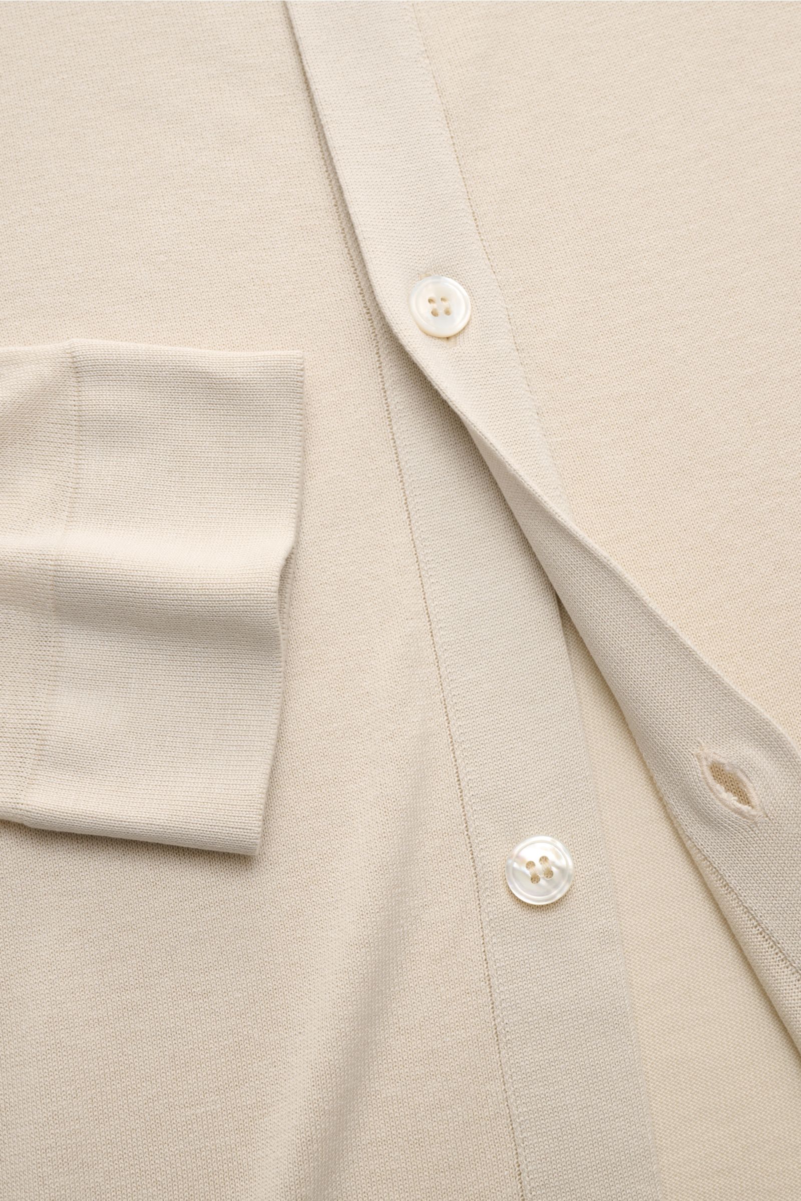 Nahaufnahme von cremefarbenem Lardini Seiden-Strickhemd aus feiner reiner Seide mit glatter Knopfleiste, Umlegekragen, Slim Fit und doppelt gearbeiteten Saumabschlüssen, sehr weichem Griff und feinem Strickbild, fotografiert von oben.