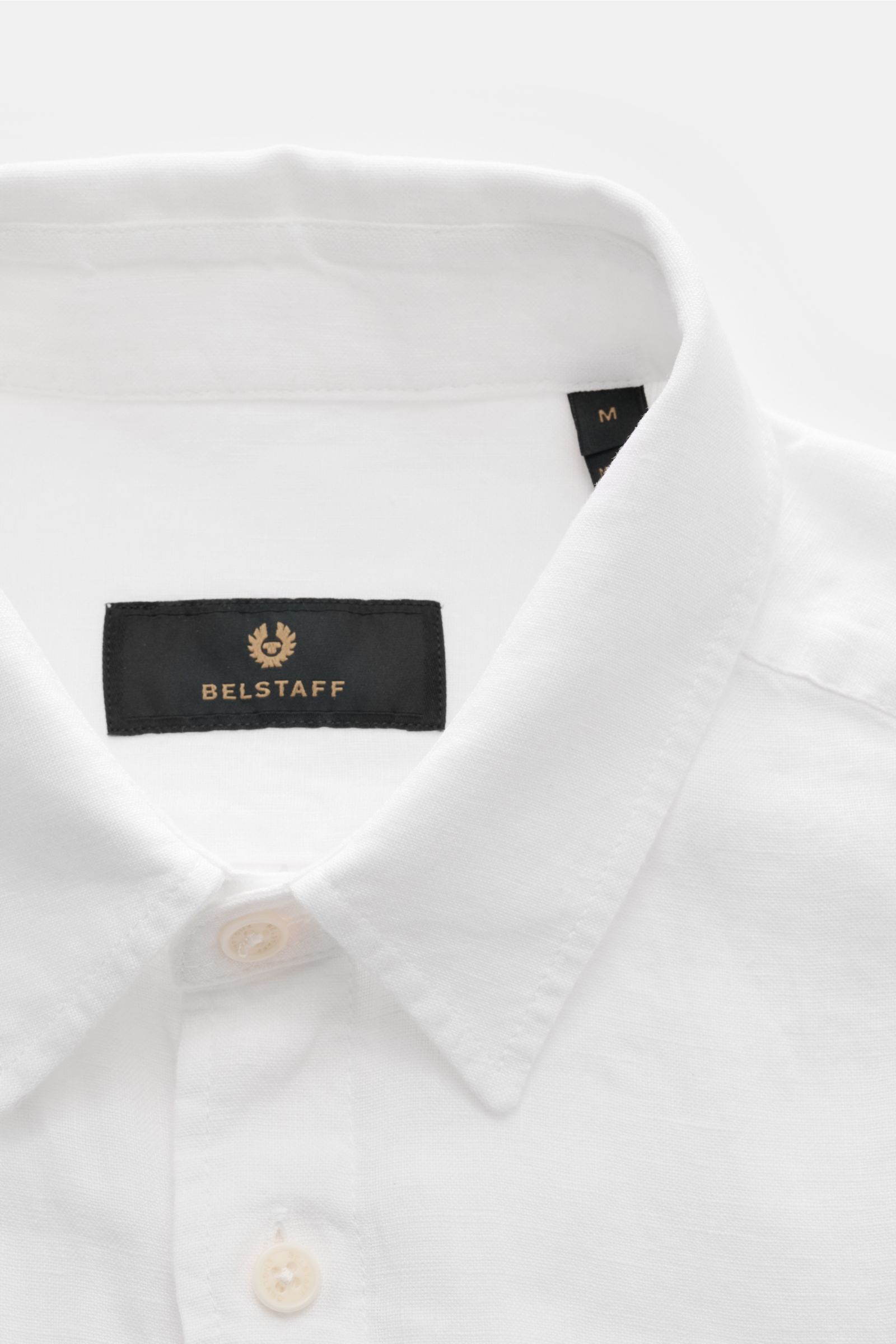 Belstaff Leinenhemd schmaler Kragen weiß, Nahaufnahme von vorne, reines Leinen, klassische Knöpfe und schwarzes Markenlabel innen.