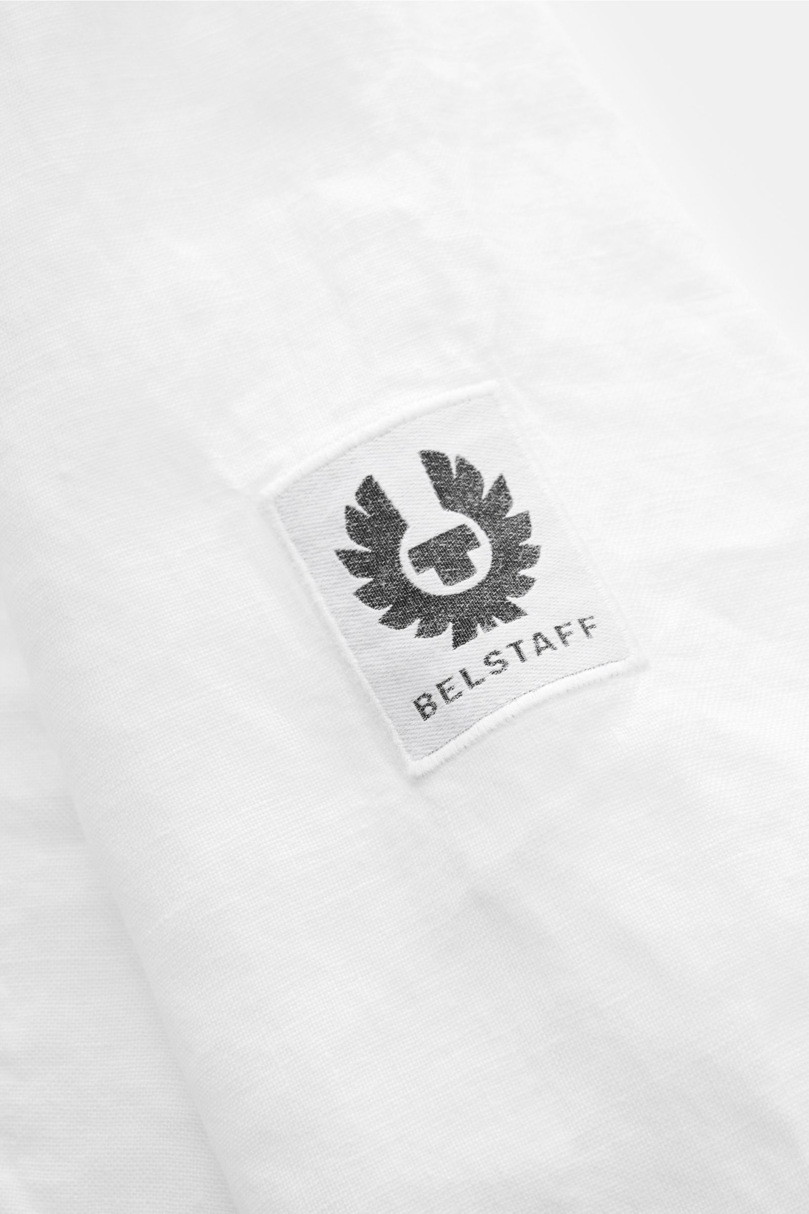 Belstaff Leinenhemd schmaler Kragen weiß, Detailaufnahme des BELSTAFF-Weblabels auf der aufgesetzten Brusttasche aus reinem Leinen.