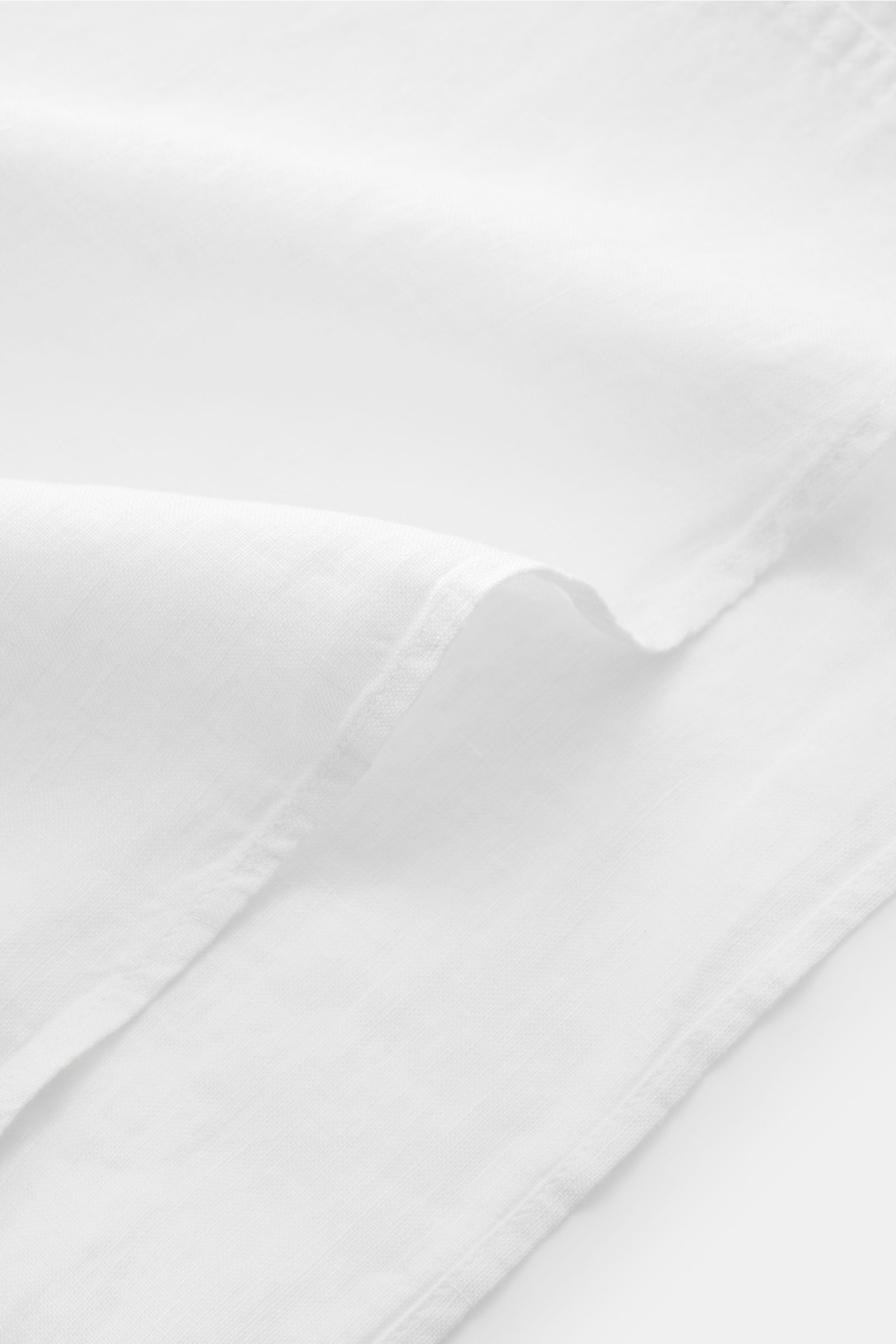 Belstaff Leinenhemd schmaler Kragen weiß aus reinem Leinen, weicher Griff, Detailaufnahme der Stoffstruktur und Naht aus naher Perspektive.