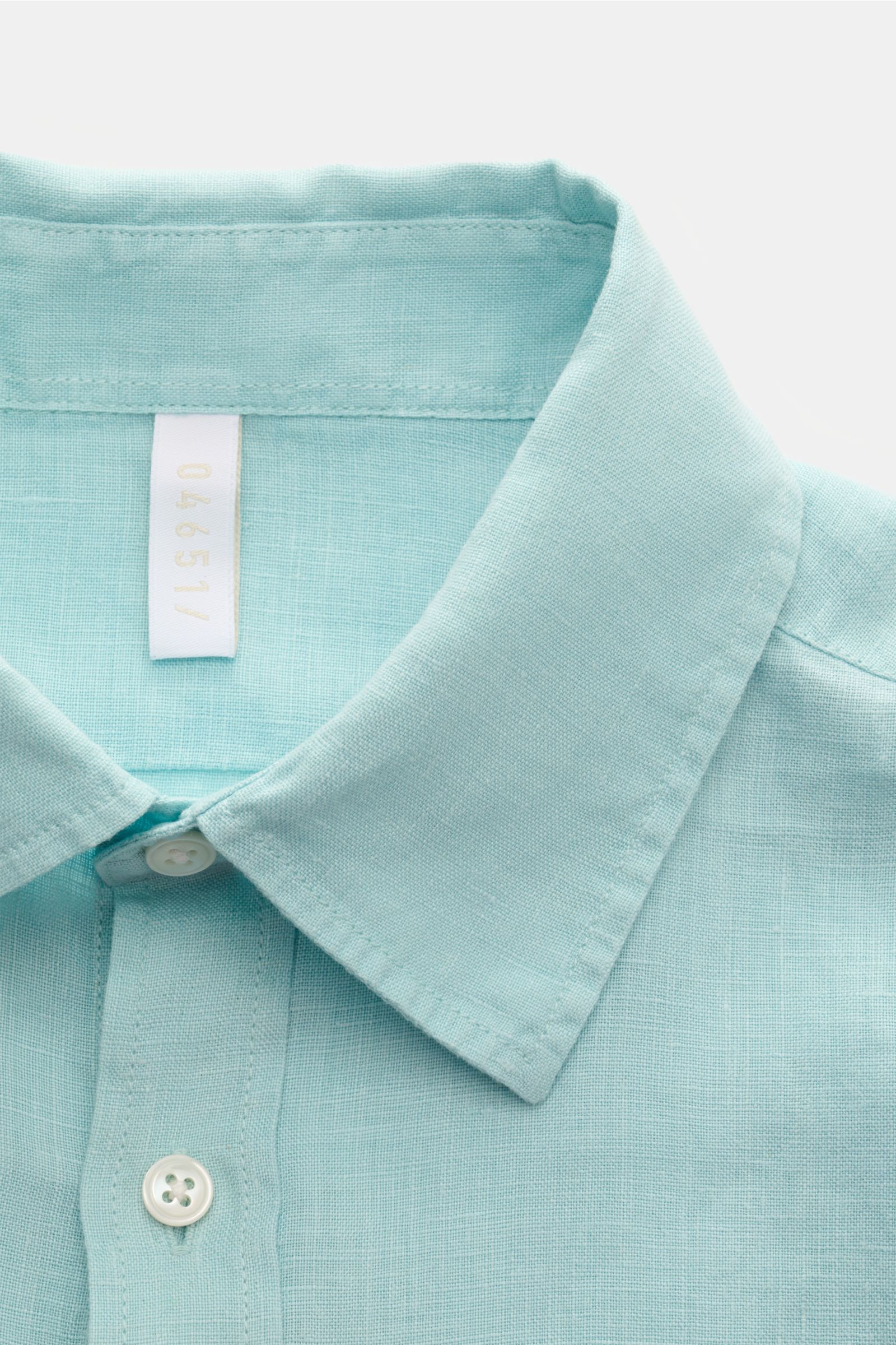 Close-up front view of the 04651/ A trip in a bag Leinenhemd Kent-Kragen türkis, a turquoise pure linen shirt with soft touch, oversized fit, Kent collar, button placket, classic cuffs, back waist darts, and slightly rounded hem. Ideal für die Übergangsze