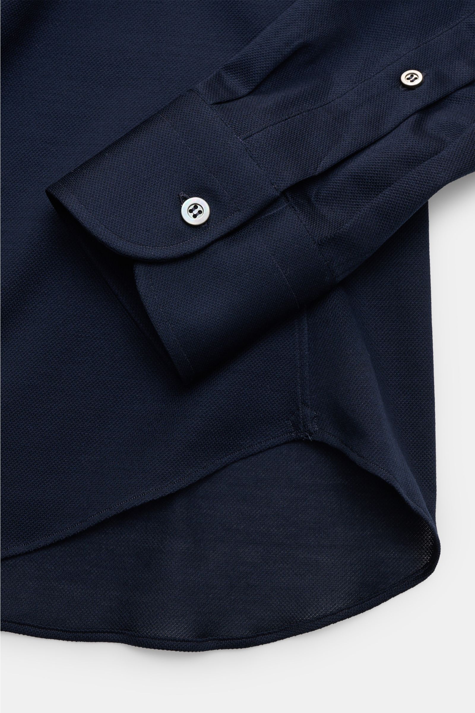 Close-up front view of Fray Piqué-Hemd Haifisch-Kragen 'Lione Cucitura' navy sleeve and curved hem, showcasing slim fit cotton piqué fabric.

FRAY überzeugt mit dem Hemd 'Lione Cucitura' aus luftigem Piqué, gefertigt aus reiner Baumwolle – ein zeitlose