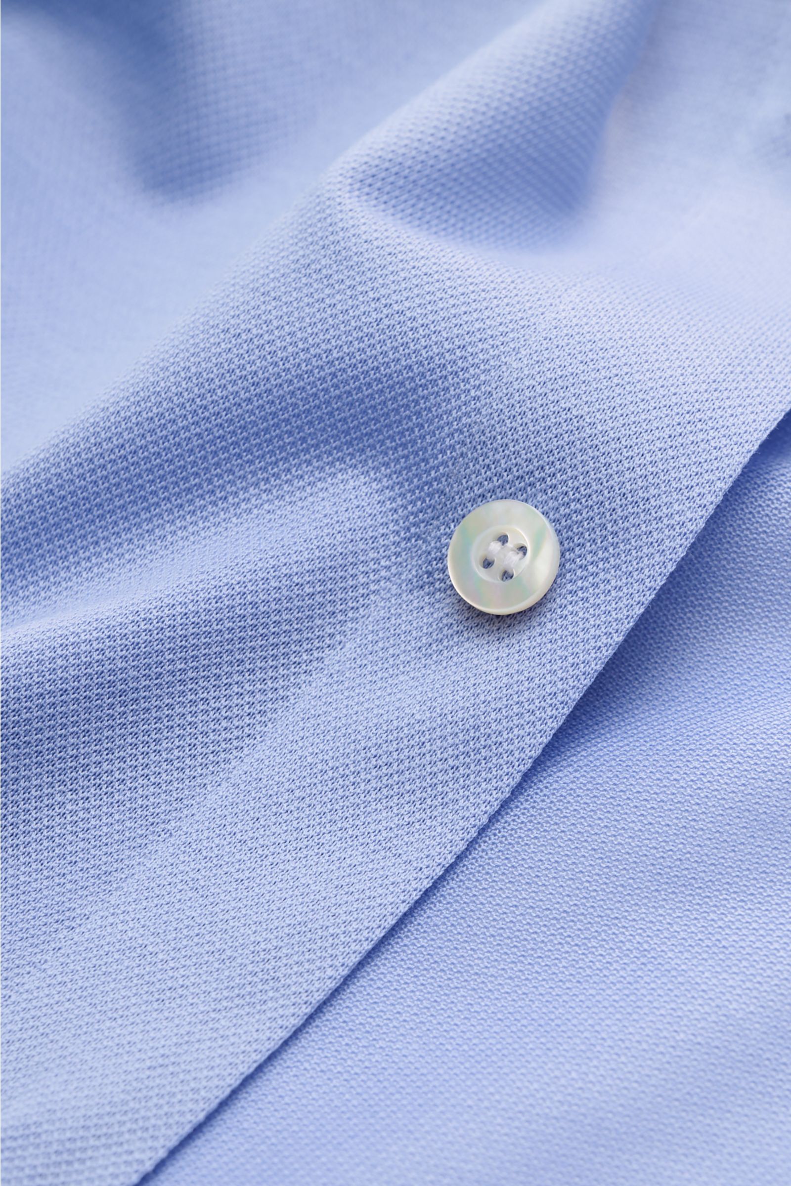 Close-up front view of the Fray Piqué-Hemd Haifisch-Kragen 'Lione Cucitura' hellblau, showing light blue piqué cotton fabric with a button. FRAY überzeugt mit dem Hemd 'Lione Cucitura' aus luftigem Piqué, gefertigt aus reiner Baumwolle – ein zeitloses 