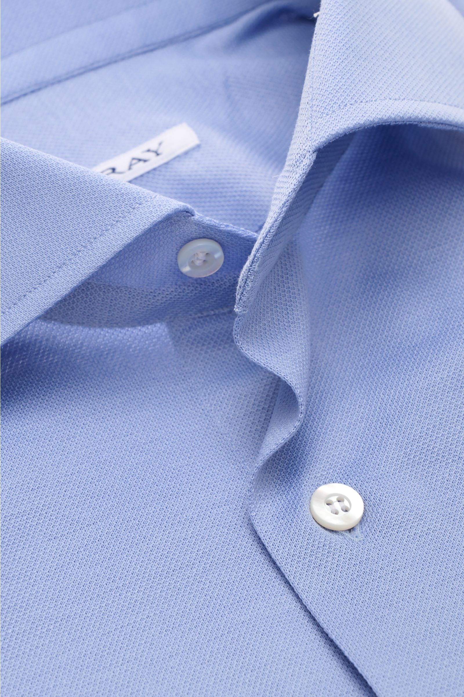 Close-up front view of the light blue Fray Piqué-Hemd Haifisch-Kragen 'Lione Cucitura' showing its shark collar and buttons, made of pure cotton piqué with a slightly textured feel, slim fit, classic sport cuffs, back waist darts, and gently rounded hem –