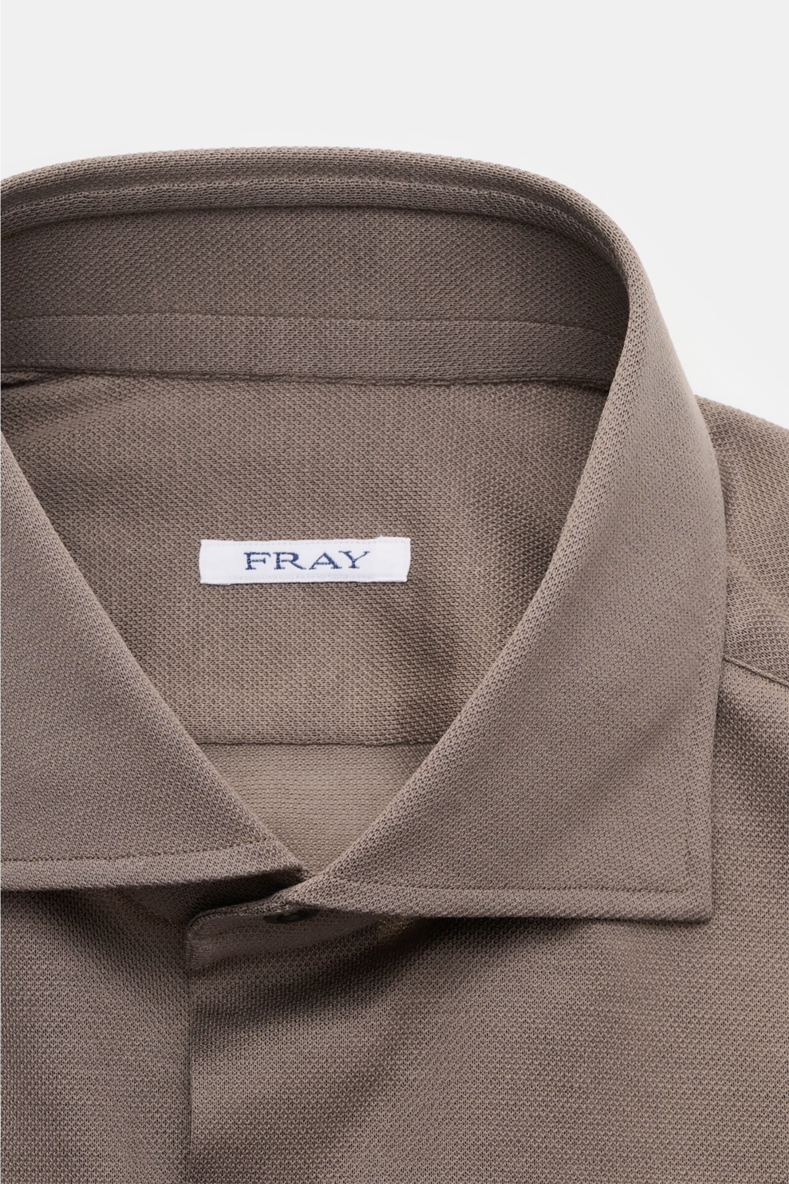 Close-up front view of the Fray Piqué-Hemd Haifisch-Kragen 'Lione Cucitura' graubraun showing the shark collar and textured cotton piqué fabric.

FRAY überzeugt mit dem Hemd 'Lione Cucitura' aus luftigem Piqué, gefertigt aus reiner Baumwolle – ein zeit