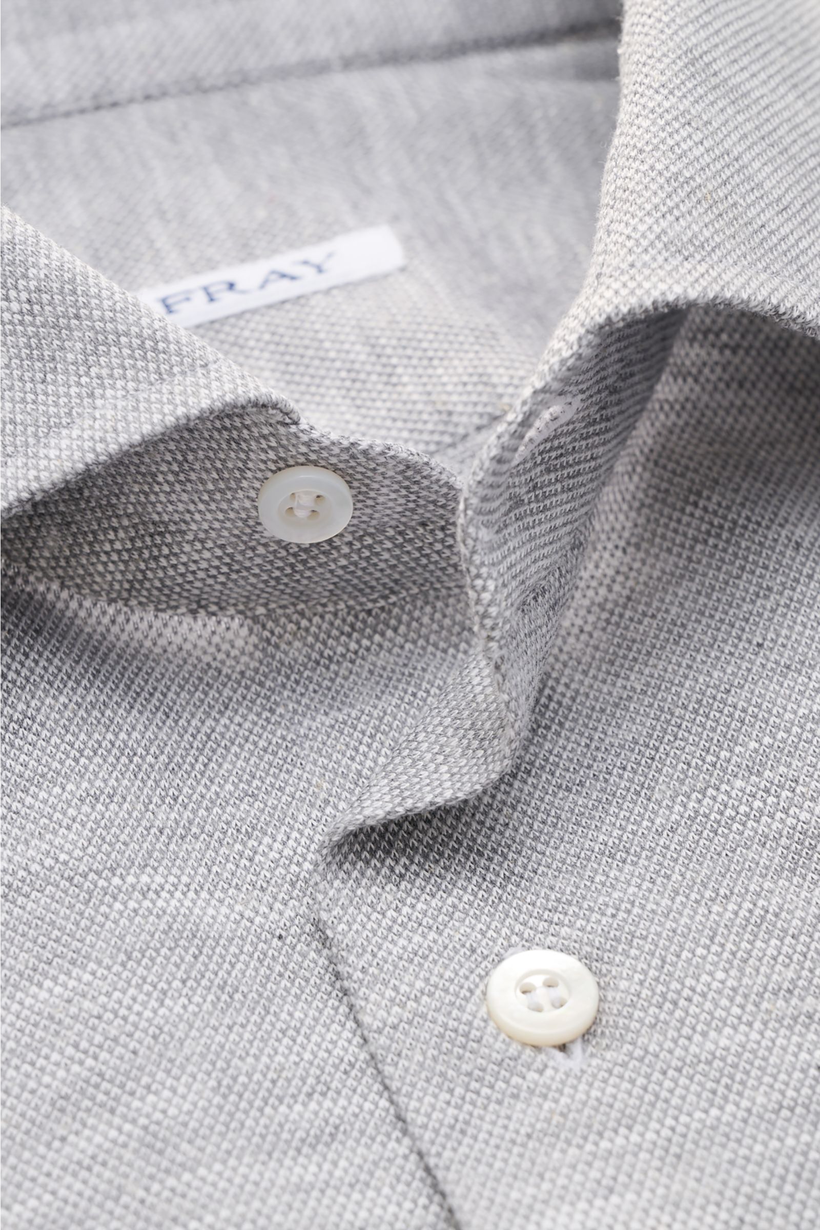 Close-up front view of the Fray Piqué-Hemd Haifisch-Kragen 'Lione Cucitura' grau meliert showing the shark collar and buttons on breathable pure cotton piqué fabric.

FRAY überzeugt mit dem Hemd 'Lione Cucitura' aus luftigem Piqué, gefertigt aus reiner