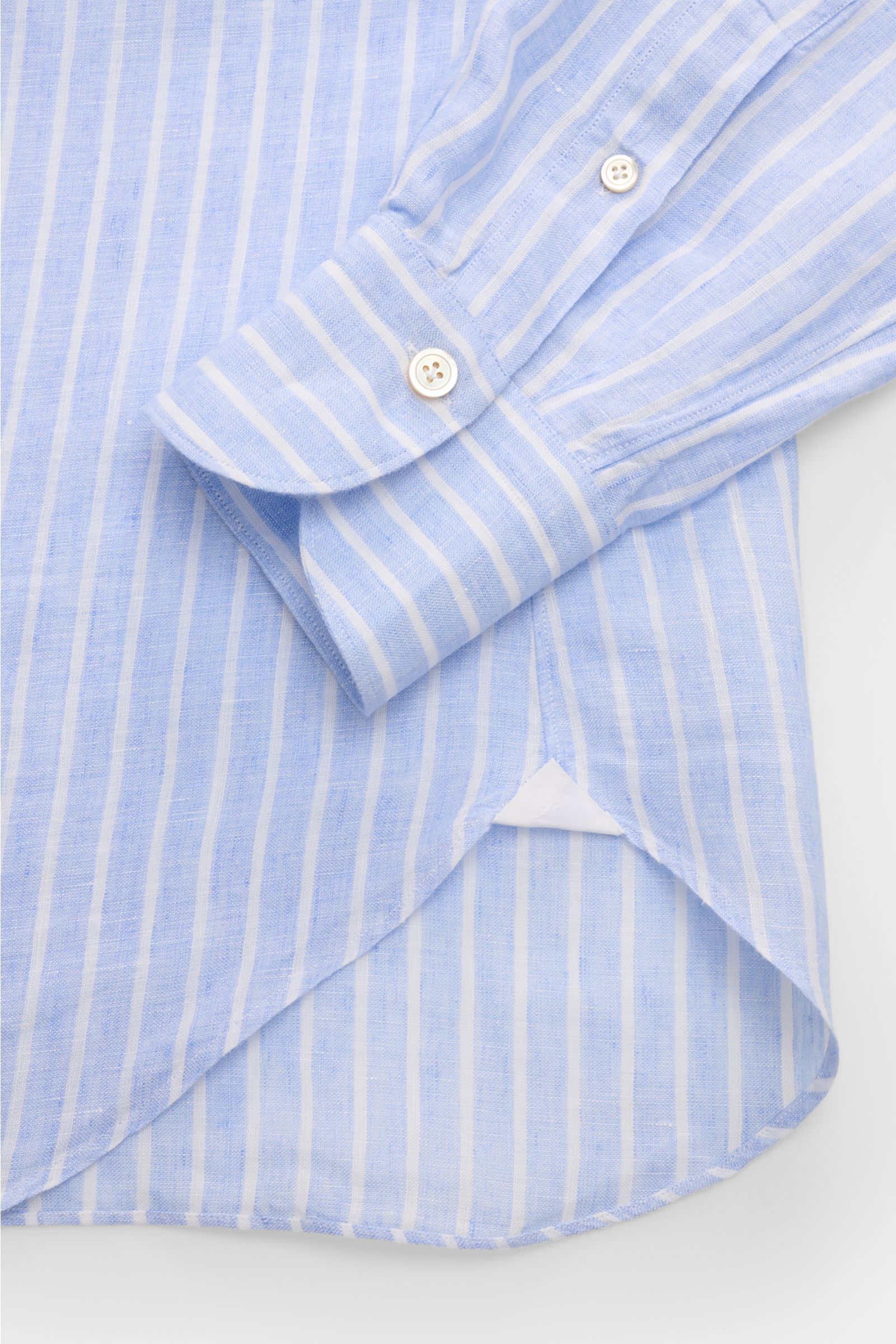 Close-up front view of the Finamore Linen shirt 'Sergio Gaeta' shark collar light blue/white striped showing cuff, fabric texture, and rounded hem.

Stylish summer essential: The lightweight linen shirt 'Sergio Gaeta' by FINAMORE works with a smart-cas