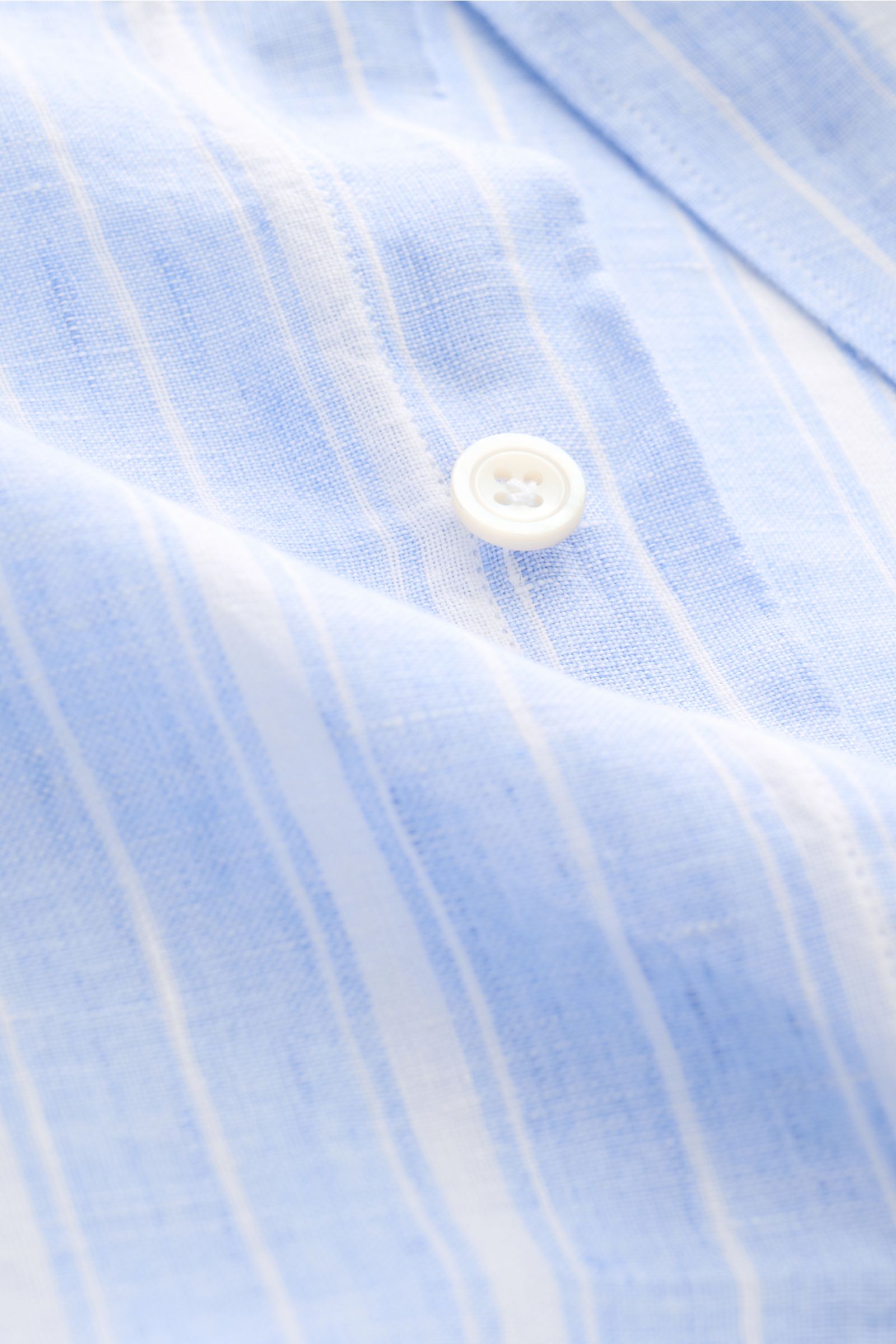 Close-up front view of the Finamore Linen shirt 'Sergio Gaeta' shark collar blue/white striped showing fabric texture and white button.

Stylish summer essential: The lightweight linen shirt 'Sergio Gaeta' by FINAMORE works with a smart-casual jacket a