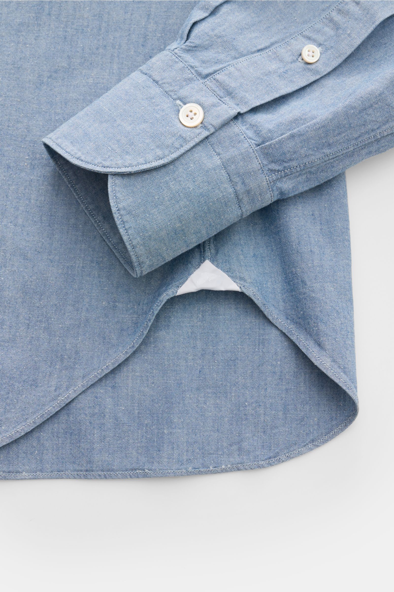 Nahaufnahme aus seitlicher Perspektive des Finamore Jeanshemds 'Sergio Gaeta' Haifisch-Kragen rauchblau mit gerundetem Saum, extralangen Ärmeln und klassischer Sportmanschette.
