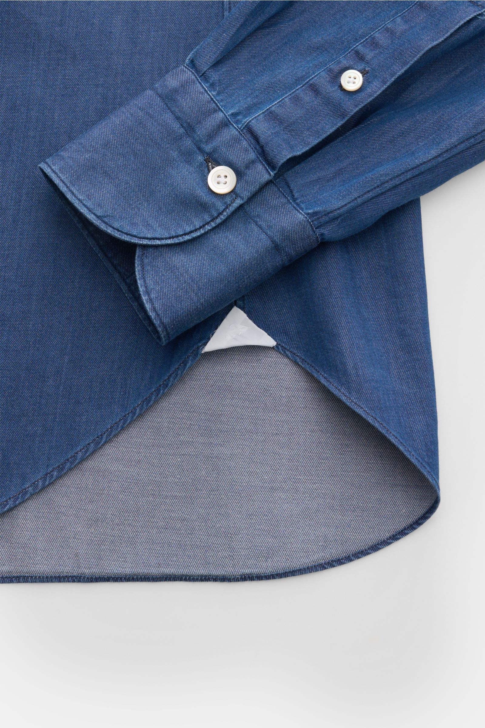 Nahaufnahme des Finamore Jeanshemds 'Sergio Gaeta' Haifisch-Kragen dunkelblau mit extralangem Ärmel, klassischer Sportmanschette und gerundetem Saum, aufgenommen von oben.
