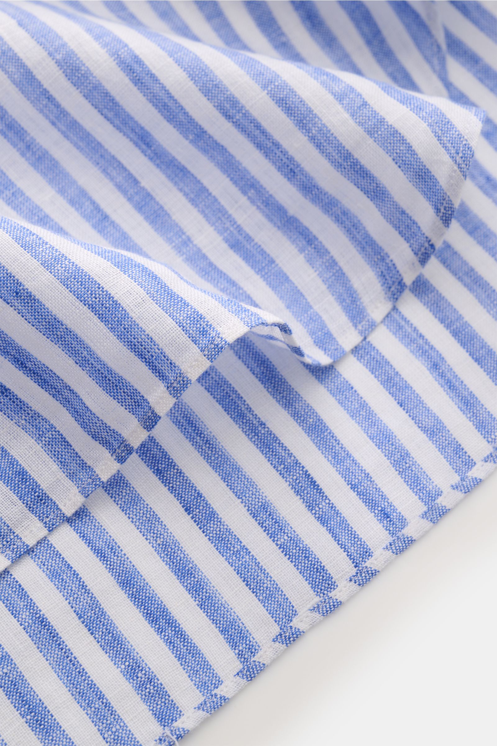 Nahaufnahme des Borrelli Leinenhemds 'Ettore' Haifisch-Kragen blau/weiß gestreift, zeigt luftige Leinenstruktur und gerundeten Saum.