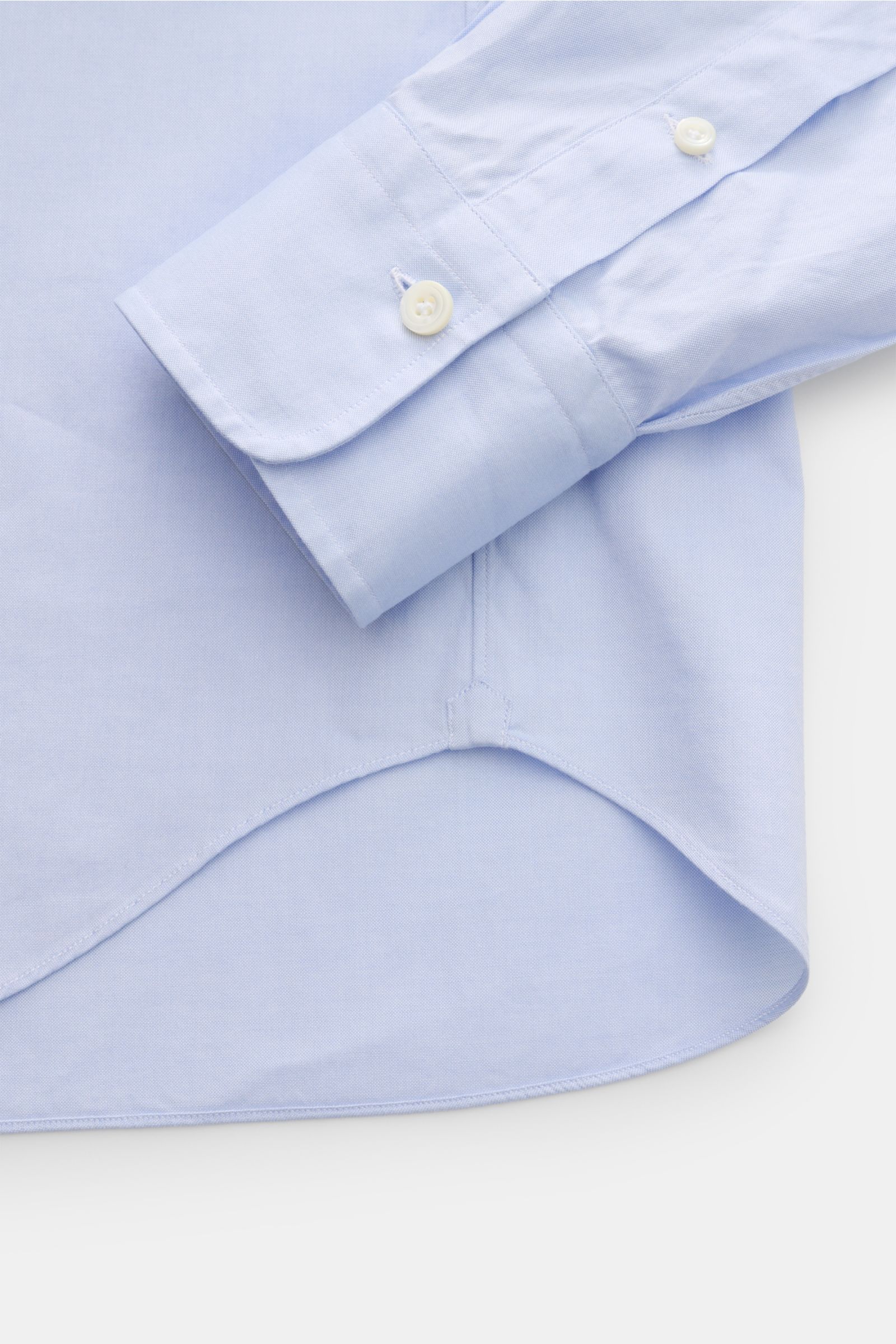 Close-up of the sleeve and rounded hem of the Gherardi Oxford shirt shark collar light blue, photographed from above. An elegant Oxford shirt in a slim fit by GHERARDI: the finest, premium quality cotton combined with a shark collar creates a stylish look