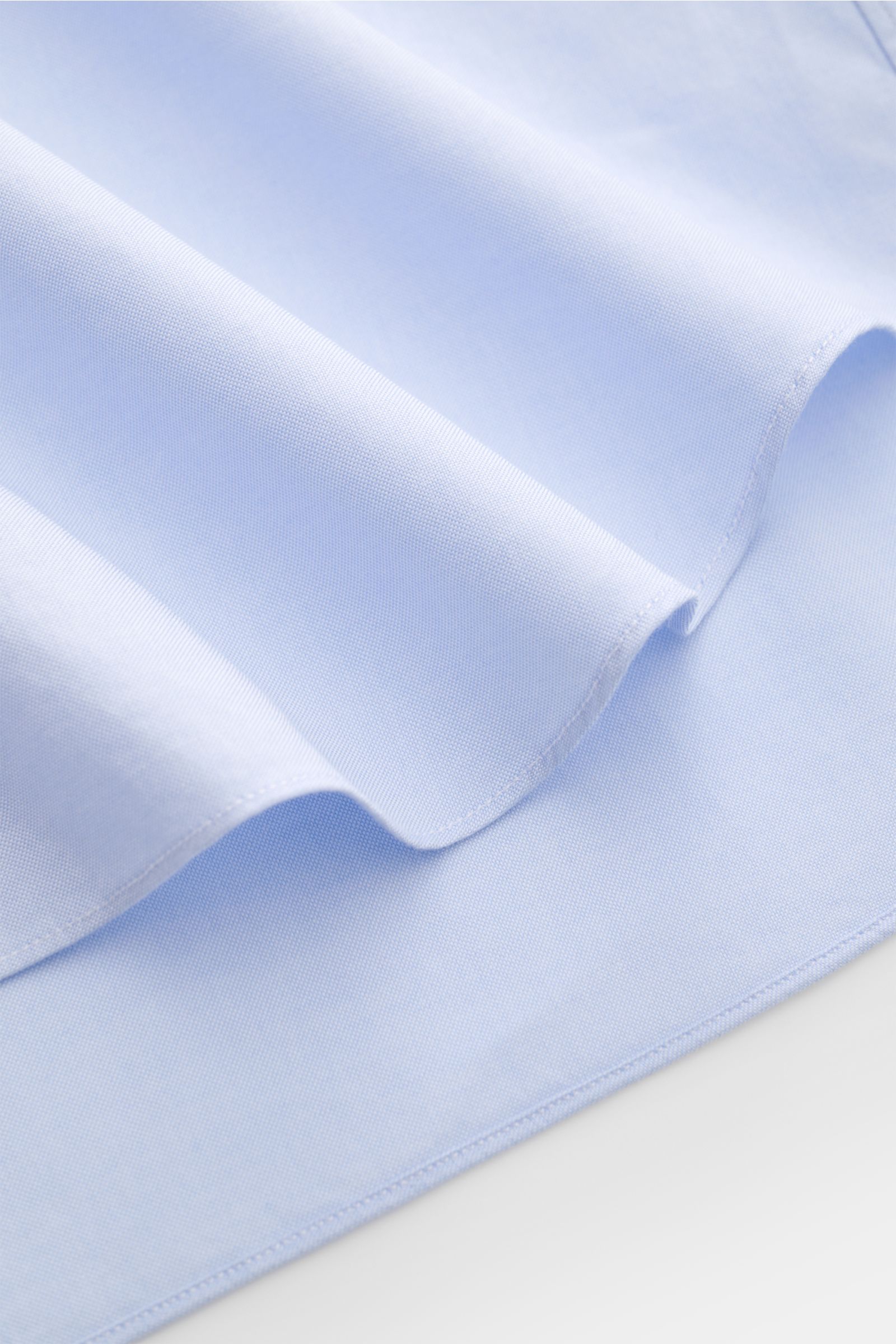 Close-up, top-down view of the light blue fabric of the Gherardi Oxford shirt shark collar light blue showing fine weave and smooth texture.

An elegant Oxford shirt in a slim fit by GHERARDI: the finest, premium quality cotton combined with a shark co