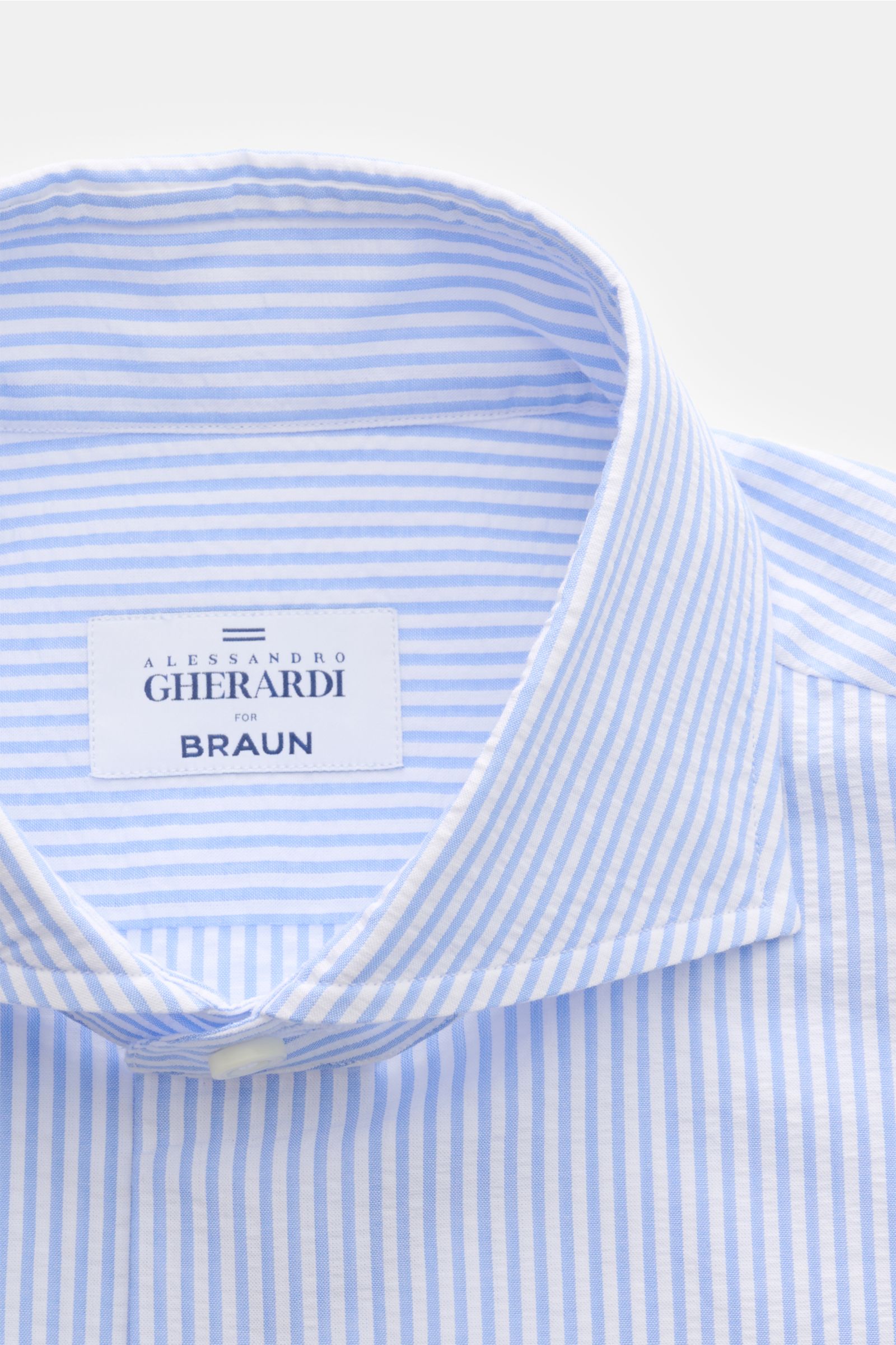 Alt tag (125 characters max): Close-up front view of Gherardi Seersucker casual shirt shark collar light blue/white striped with branded label inside collar.

This casual shirt by GIAMPAOLO is made of comfortable, fine seersucker fabric – a confident p
