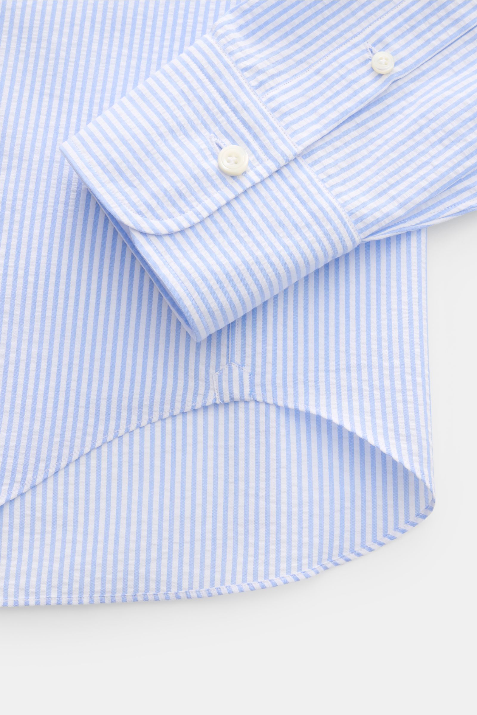 Alt tag (125 characters max):
Close-up of Gherardi Seersucker casual shirt shark collar light blue/white striped cuff and hem from above, showing fabric texture.

Detailed description:
This casual shirt by GIAMPAOLO is made of comfortable, fine seersuc