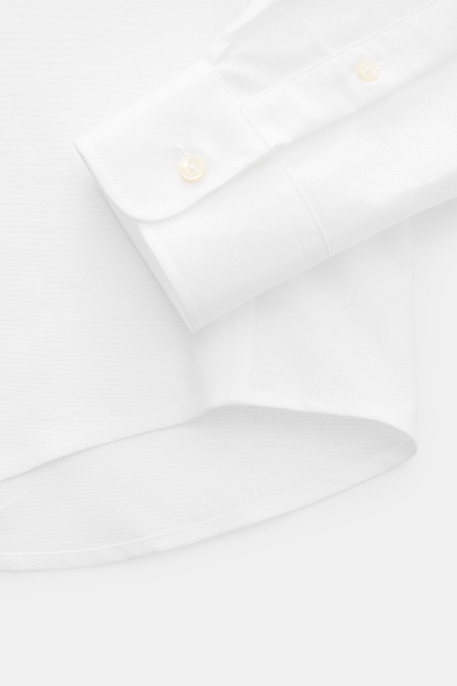 Close-up top-down view of the Ami Paris Oxford shirt button-down collar white showing the cuff, button placket, and rounded hem in pure white Oxford cotton.

For relaxed casual styles and more formal looks: This elegant shirt from AMI PARIS with signat