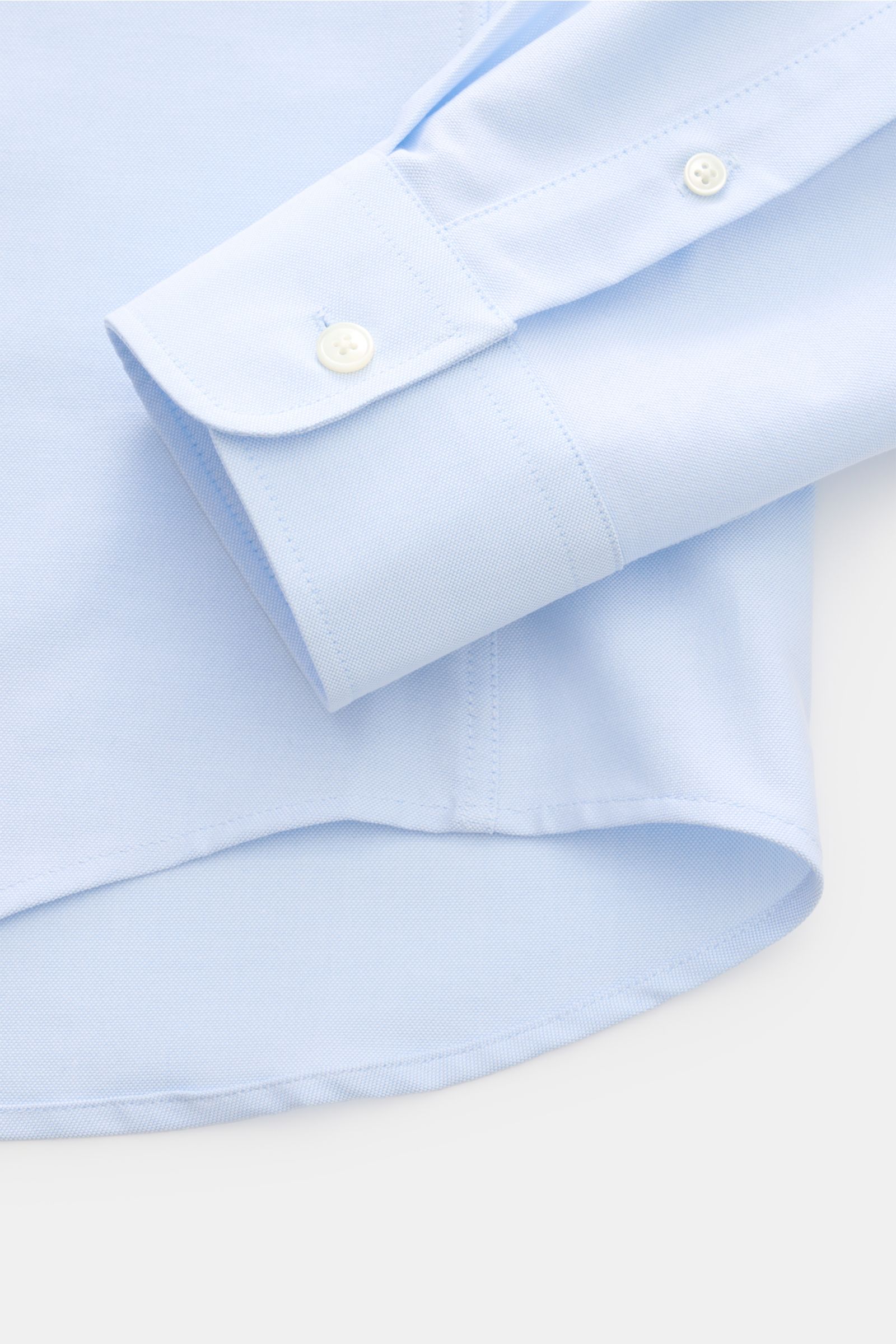 Close-up front view of Ami Paris Oxford shirt button-down collar light blue showing cuff, button, and rounded hem in pure cotton Oxford fabric.

For relaxed casual styles and more formal looks: This elegant shirt from AMI PARIS with signature heart sti