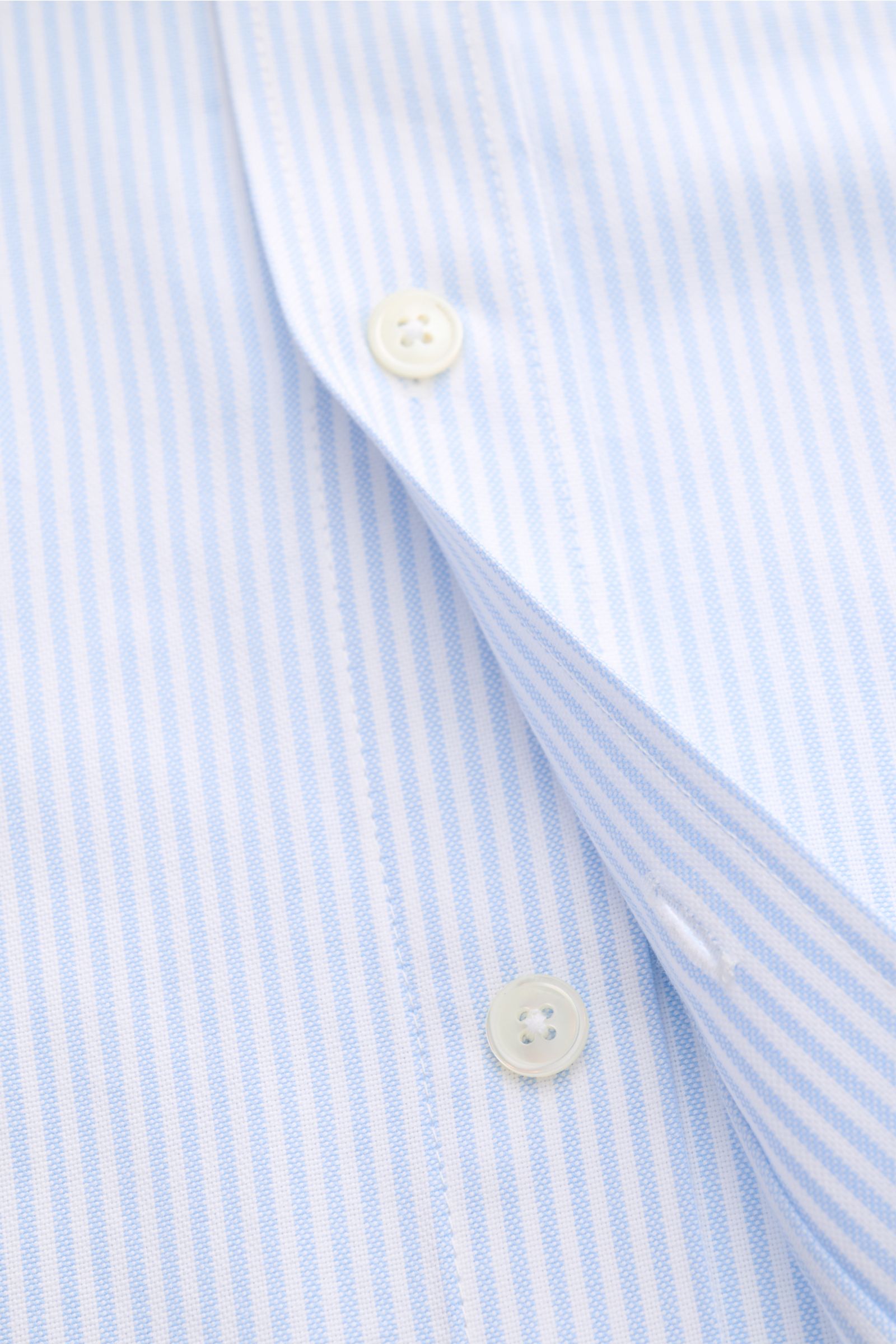 Ami Paris Casual Hemd Button-Down-Kragen hellblau/weiß gestreift, Detailansicht Knopfleiste und weiche Baumwolle, Oversized Fit, klassisch modern.