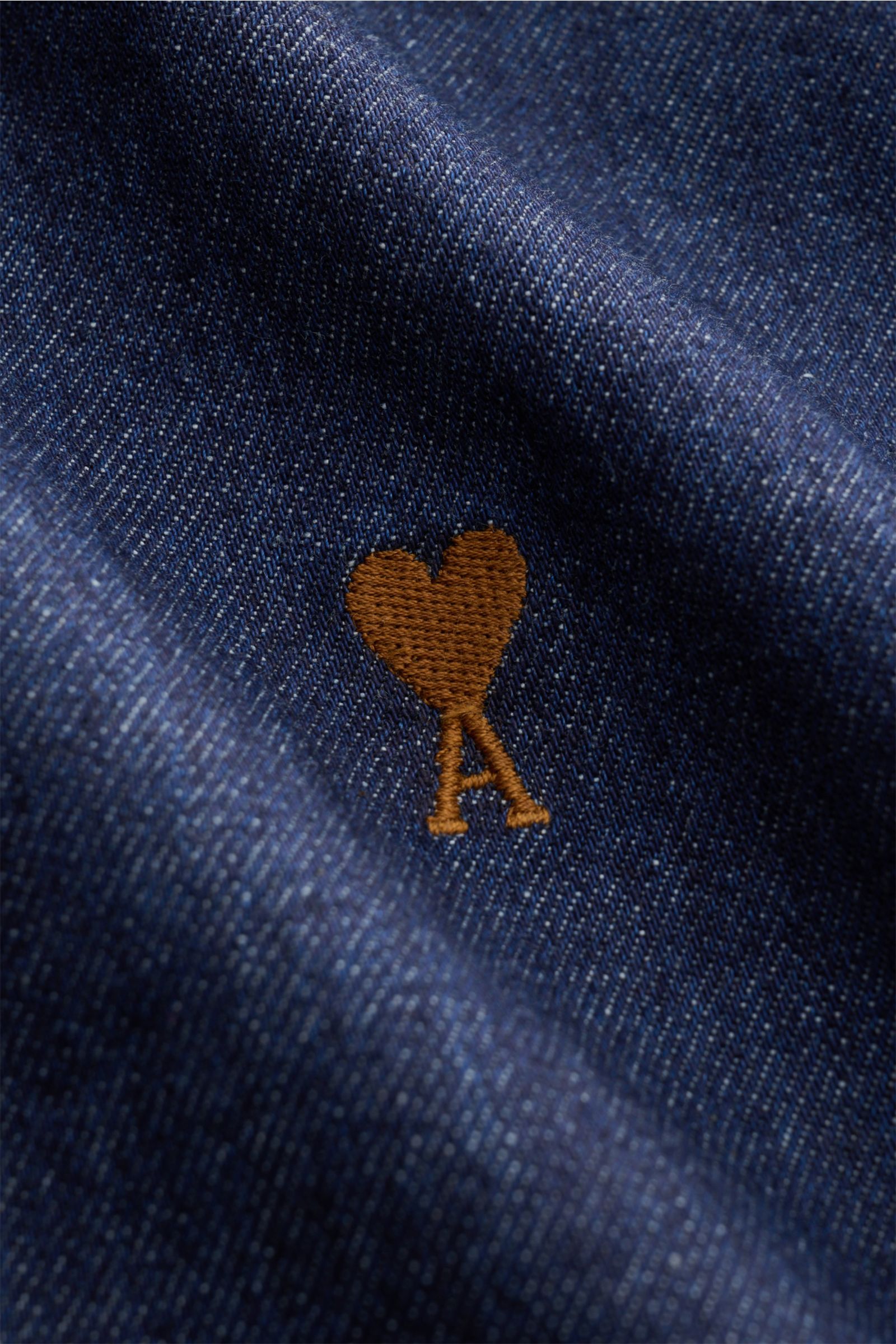 Ami Paris Jeanshemd Button-Down-Kragen navy in Nahaufnahme, Detail des braunen Markenstick auf griffigem, reinem Baumwoll-Denim.