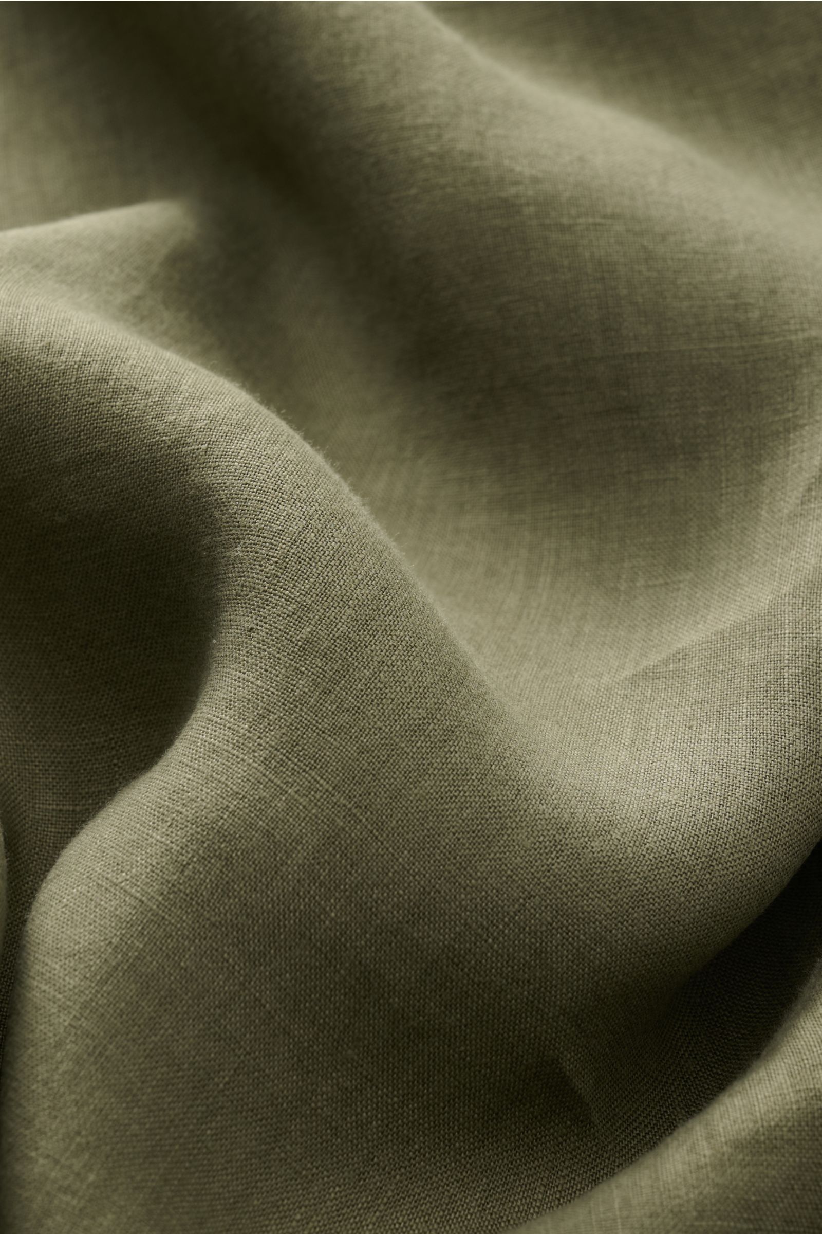Nahaufnahme der strukturierten, olivfarbenen Leinenqualität des von Braun Leinenhemd Haifisch-Kragen oliv, Detailfoto mit weichem Griff und luftiger Textur.