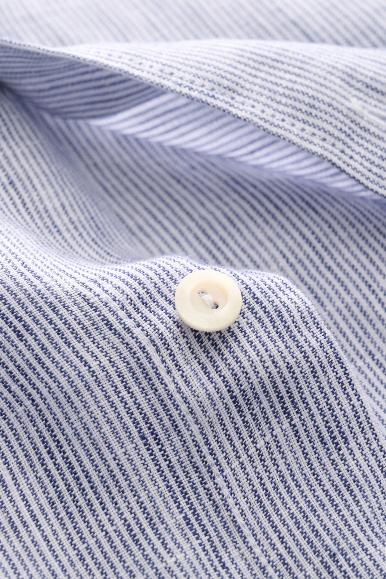Nahaufnahme aus schräger Perspektive des von Braun Leinenhemd Haifisch-Kragen navy/weiß gestreift mit feinem Streifenmuster, Knopf und strukturierter Leinenqualität.