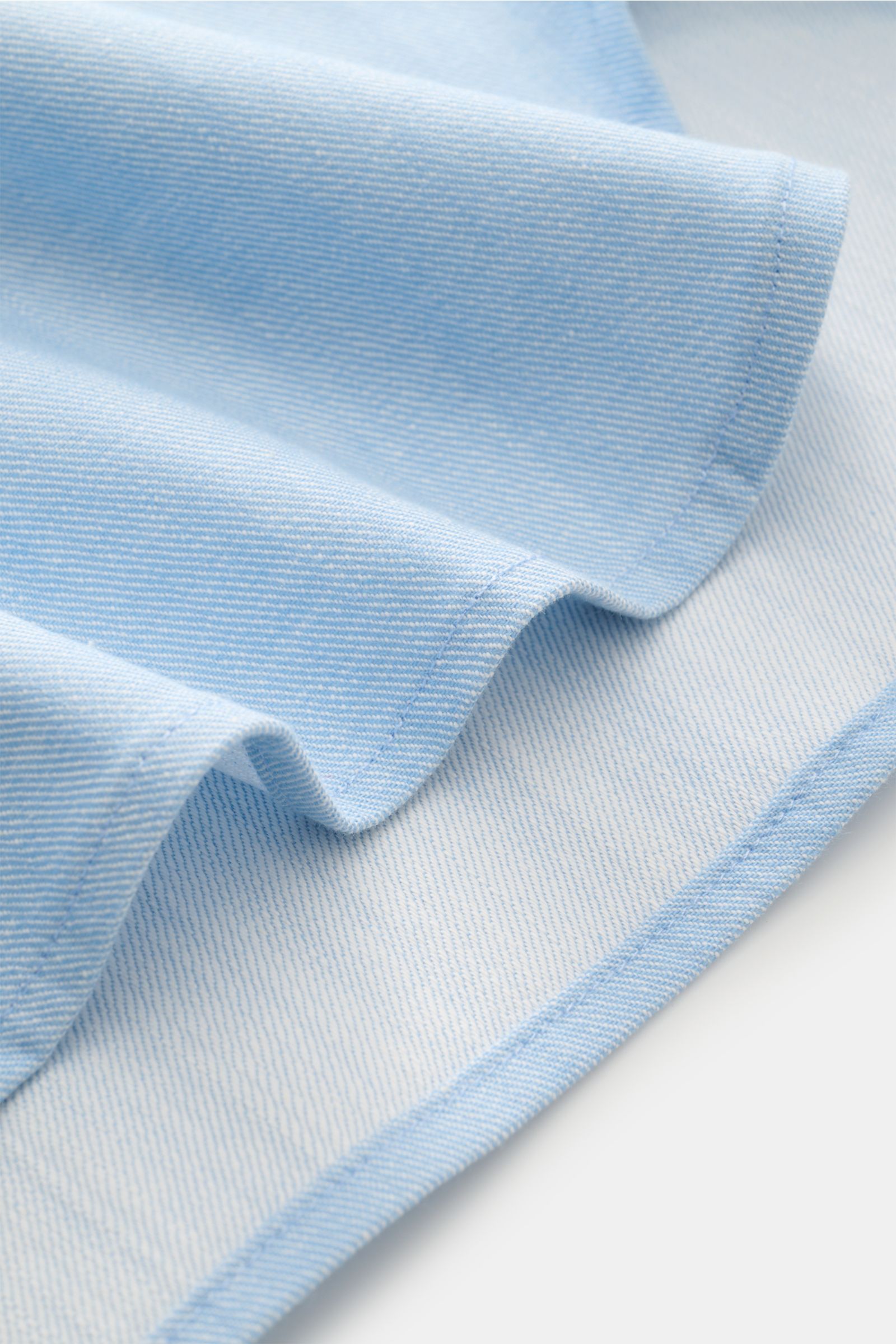 Nahaufnahme des hellblauen Doppiaa Jeanshemds 'Aariosto' mit weichem Denim und feiner Struktur, Detail der Stofffalte.