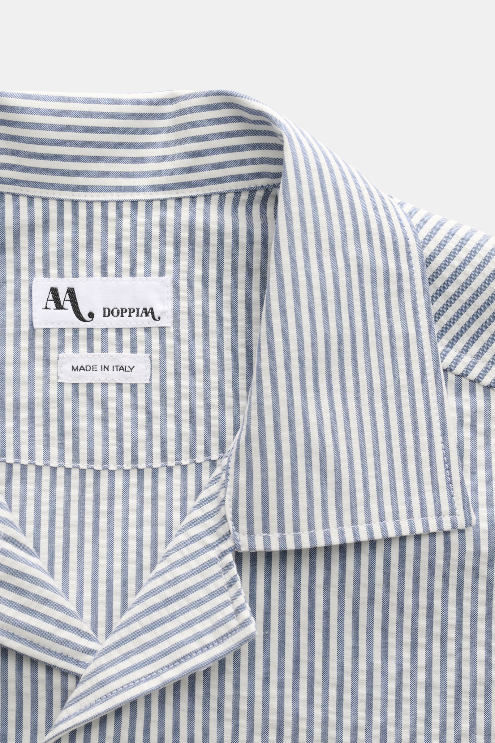 Close-up front view of the Doppiaa Seersucker-Hemd 'Aalassio' Haifisch-Kragen rauchblau with blue and white stripes, showing the collar and label. Erste Wahl für mühelose Looks ist das Seersucker-Hemd 'Aalassio' aus reiner Baumwolle von DOPPIAA, das mit K
