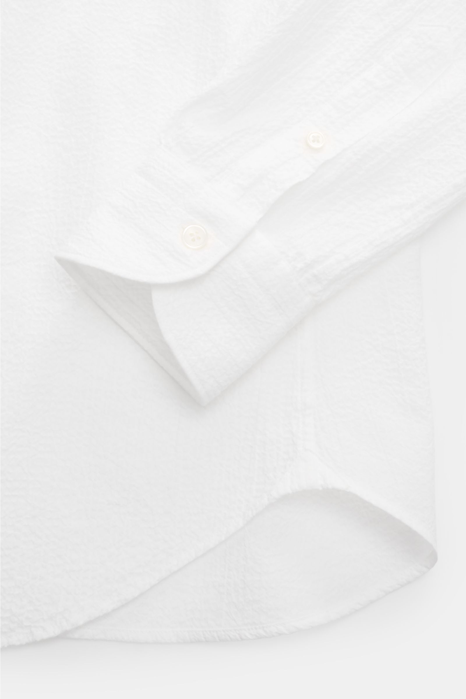 Close-up view of Guglielminotti Casual shirt shark collar white showing sleeve cuff, French button placket, and rounded hem in stretchy cotton with crinkle effect.

An elegant casual shirt with a twist: this slim model GUGLIELMINOTTI is made of stretch