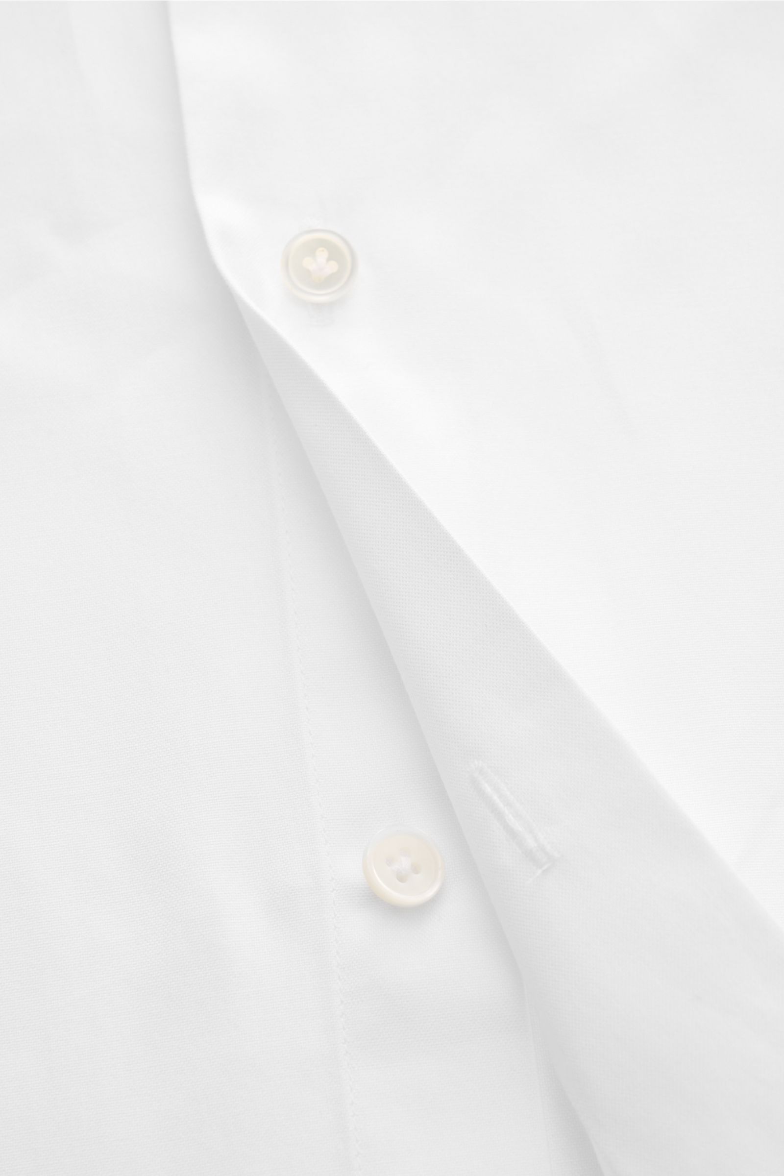 Guglielminotti Casual Hemd Haifisch-Kragen weiß, Detailaufnahme der weißen Popeline mit Knöpfen und französischer Knopfleiste aus schräger Perspektive.