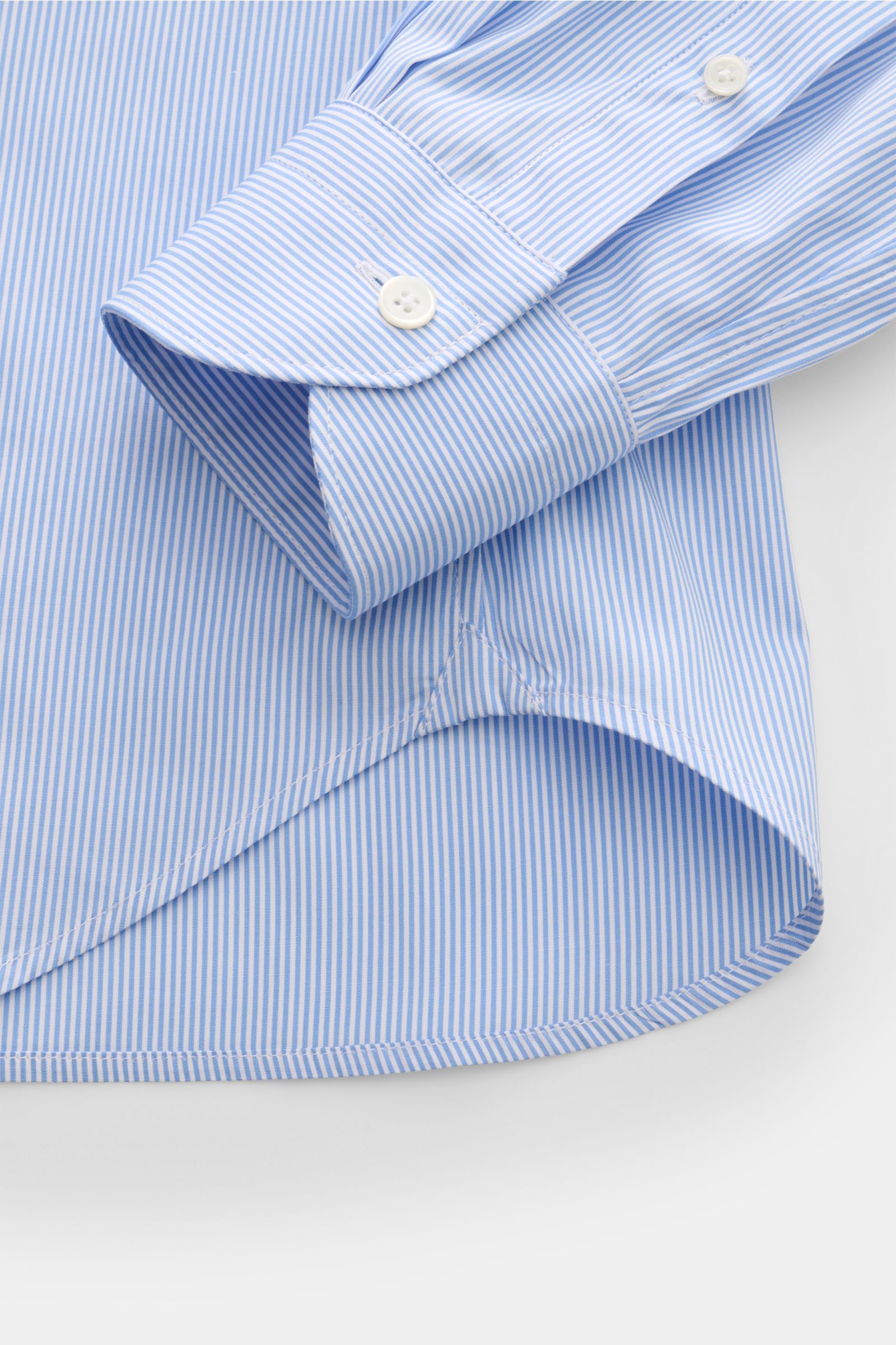 Guglielminotti Casual shirt shark collar blue/white striped shown from a close-up side angle focusing on the cuff and rounded hem, made of pure cotton with slim fit, French button placket with mother-of-pearl buttons, classic barrel cuffs, and waist darts