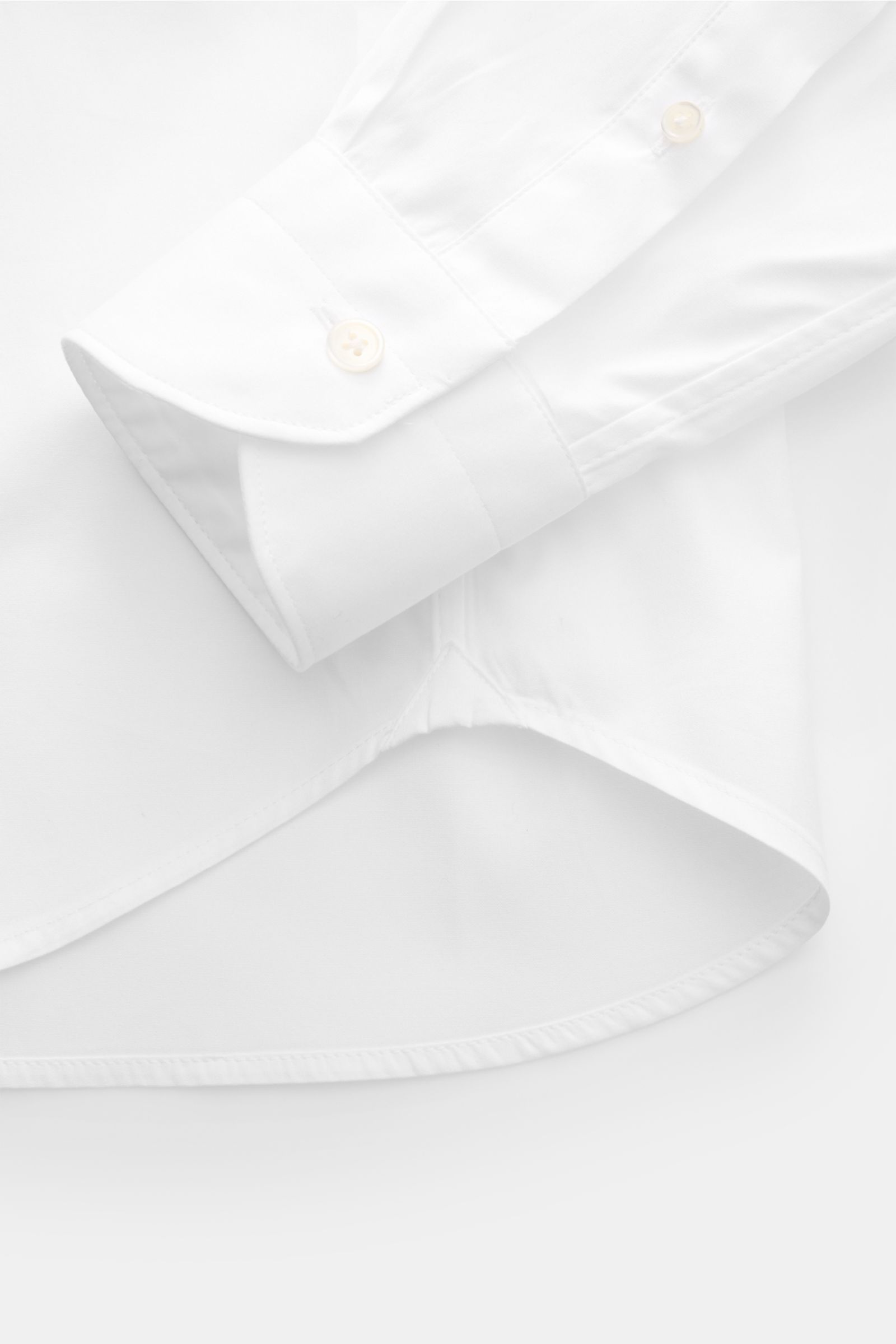Close-up angled view of the cuff and rounded hem of the Guglielminotti Casual shirt shark collar white, made of pure cotton with French mother-of-pearl buttons, slim fit, and classic barrel cuffs.