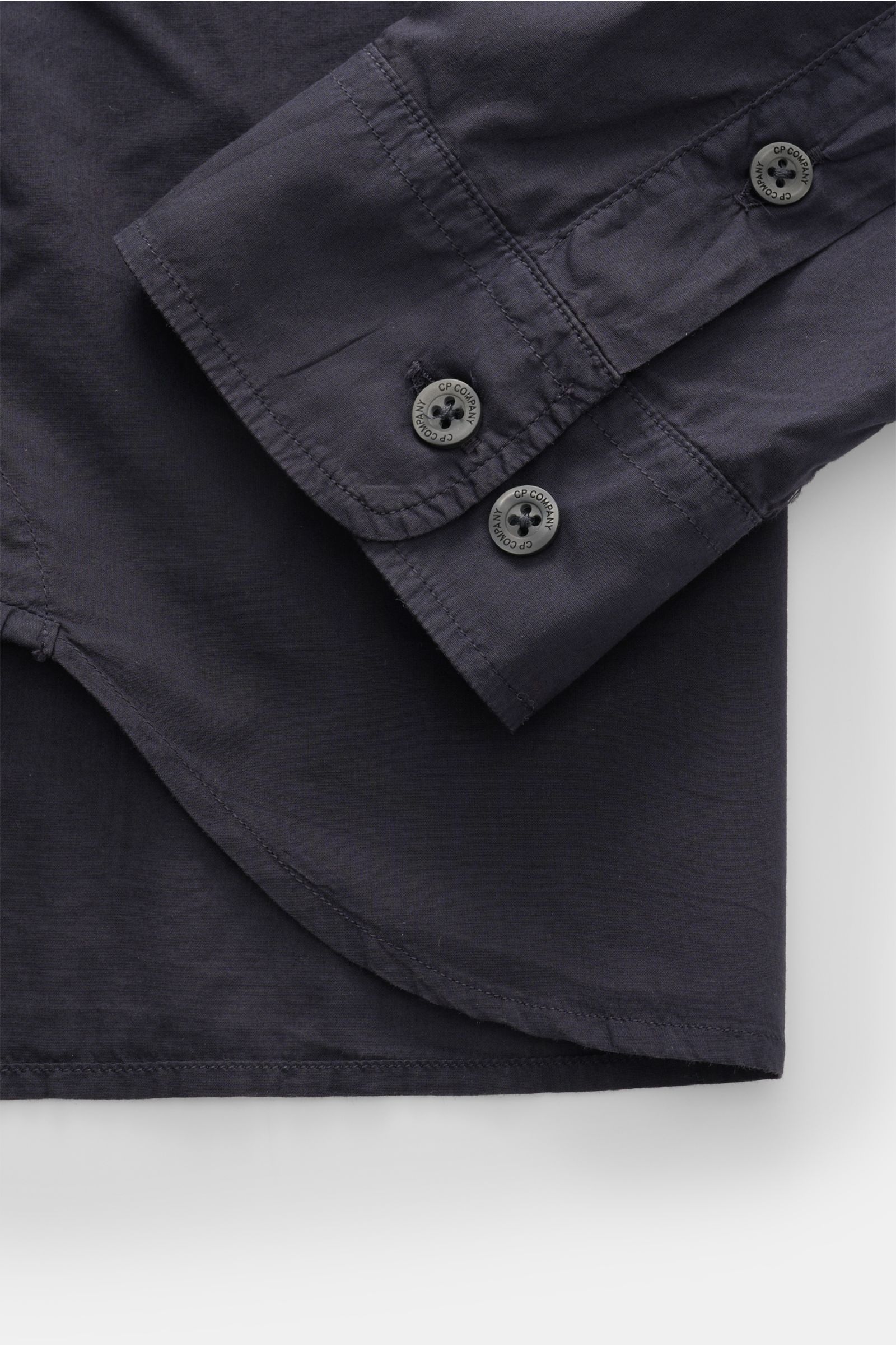C.P. Company Casual Hemd schmaler Kragen navy, Detailaufnahme der Ärmelmanschette mit Knöpfen, reine Baumwolle, navy, von oben fotografiert.