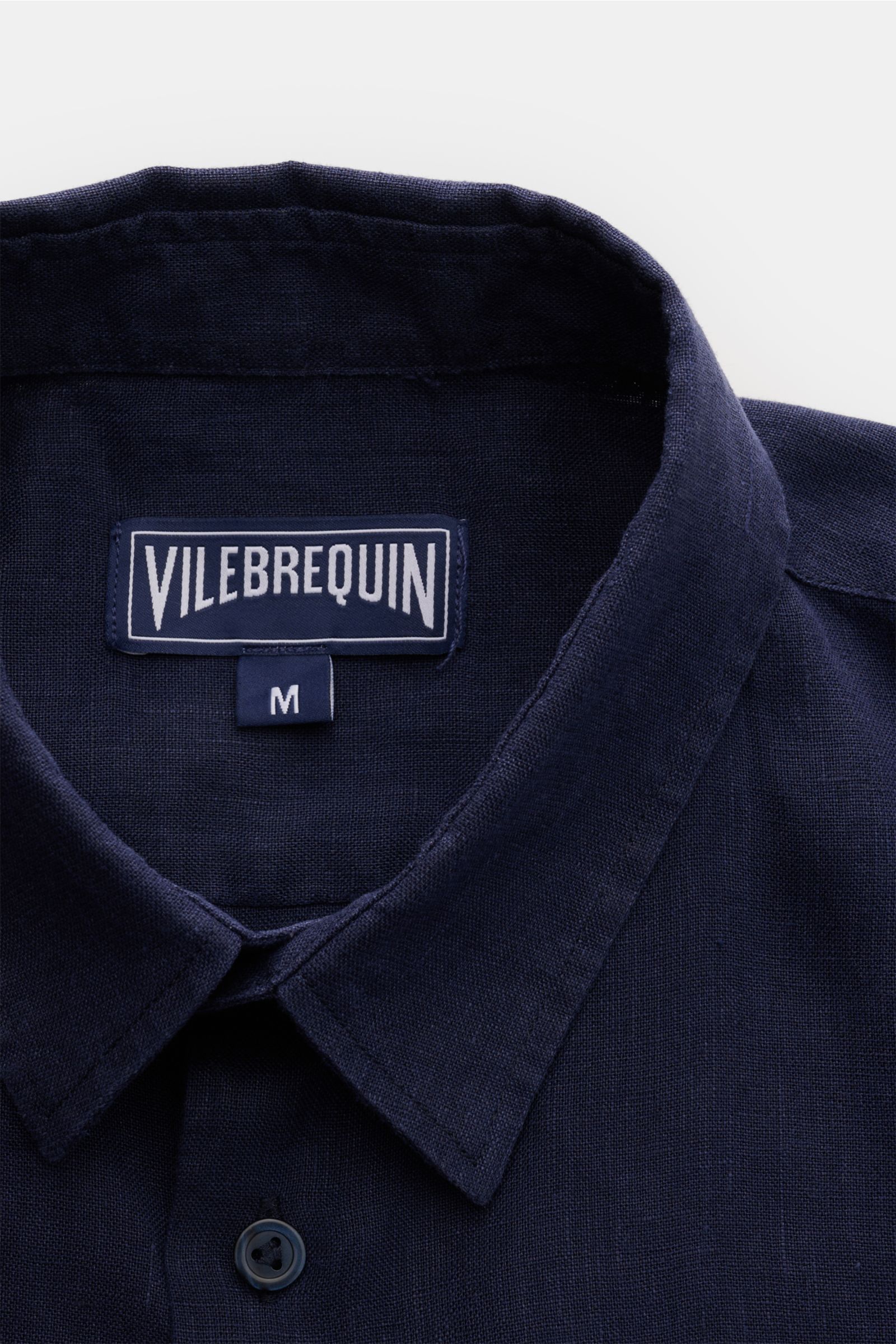 Nahaufnahme von Vilebrequin Leinenhemd schmaler Kragen navy, leichte Qualität, weicher Griff, Regular Fit, schmaler Kragen, französische Knopfleiste, klassische Sportmanschette, aufgesetzte Brusttasche, gerundeter Saumverlauf, tonales Stitching am Saum.