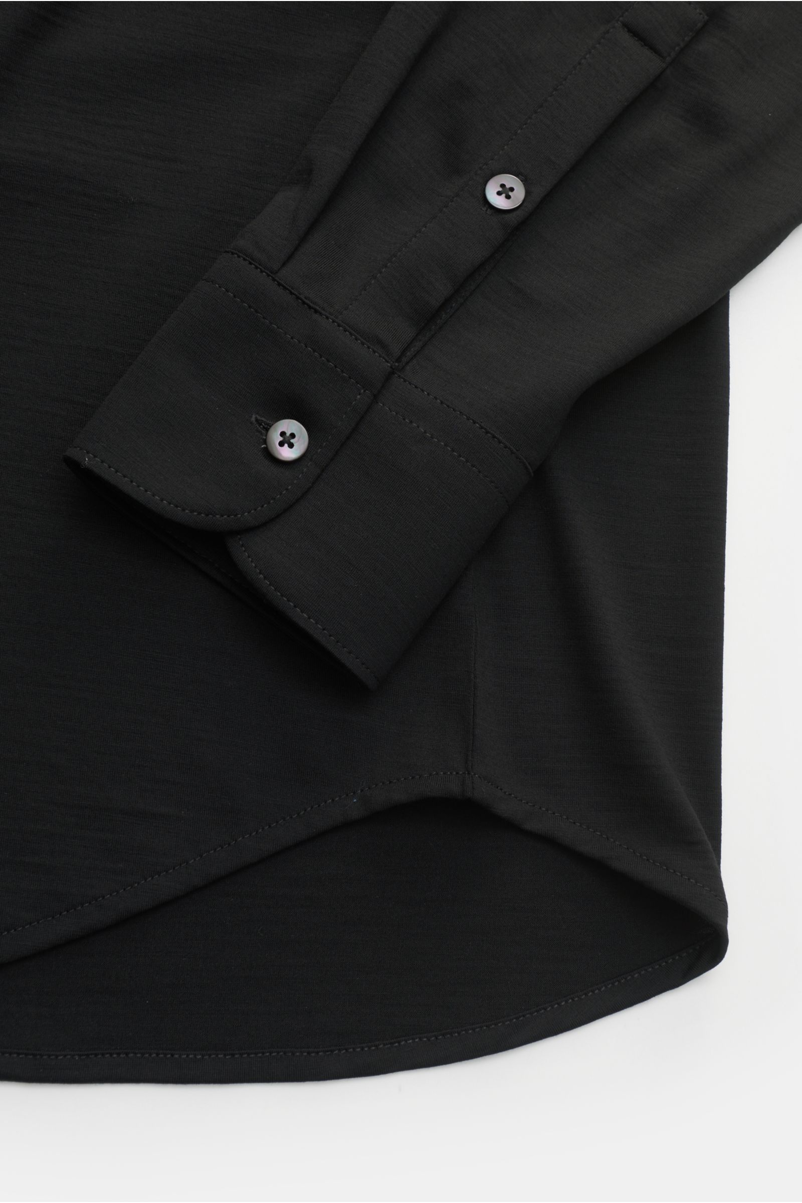Nahaufnahme des linken Ärmels und Saumverlaufs vom Stefan Brandt Jersey-Hemd 'Otis' Haifisch-Kragen schwarz, gefertigt aus flexiblem, geschmeidigem Jersey aus reiner Pima-Baumwolle mit weichem Griff, Extra Slim Fit, französischer Knopfleiste, klassischer 
