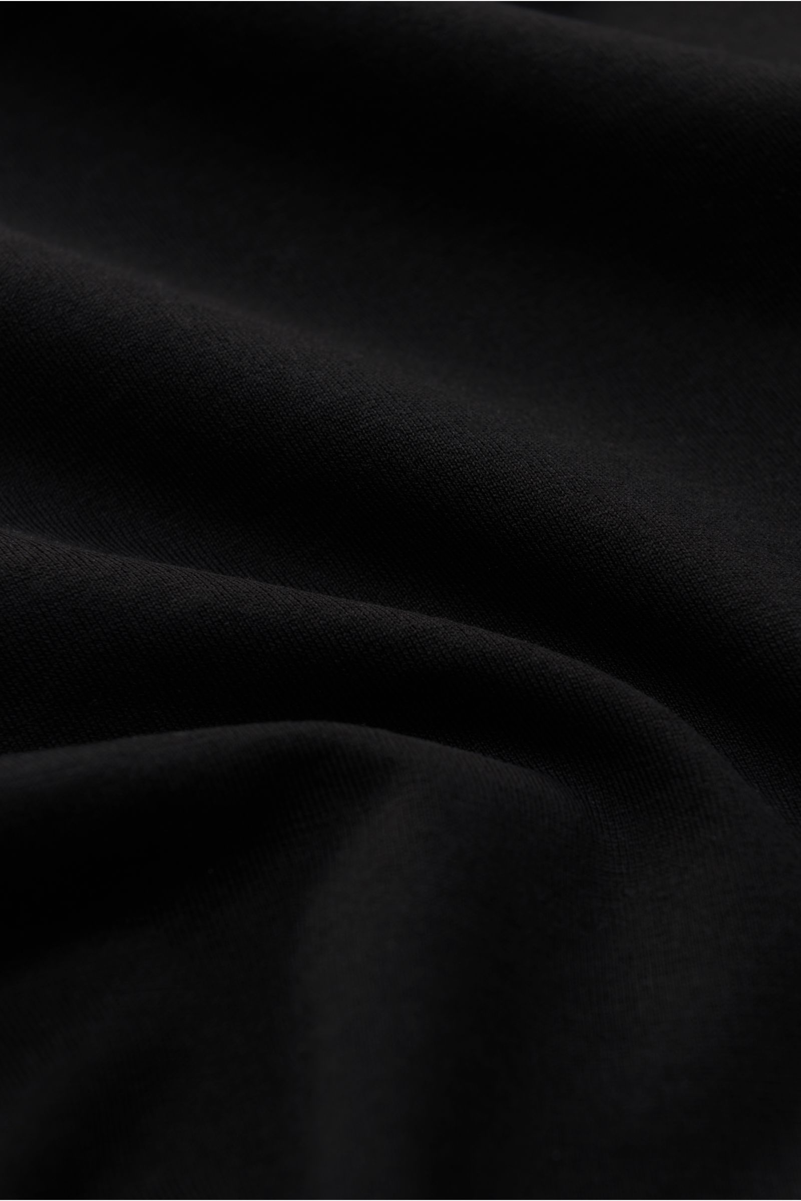 Nahaufnahme des flexiblen, schwarzen Stefan Brandt Jersey-Hemds 'Otis' mit Haifisch-Kragen aus glattem Pima-Baumwoll-Jersey.