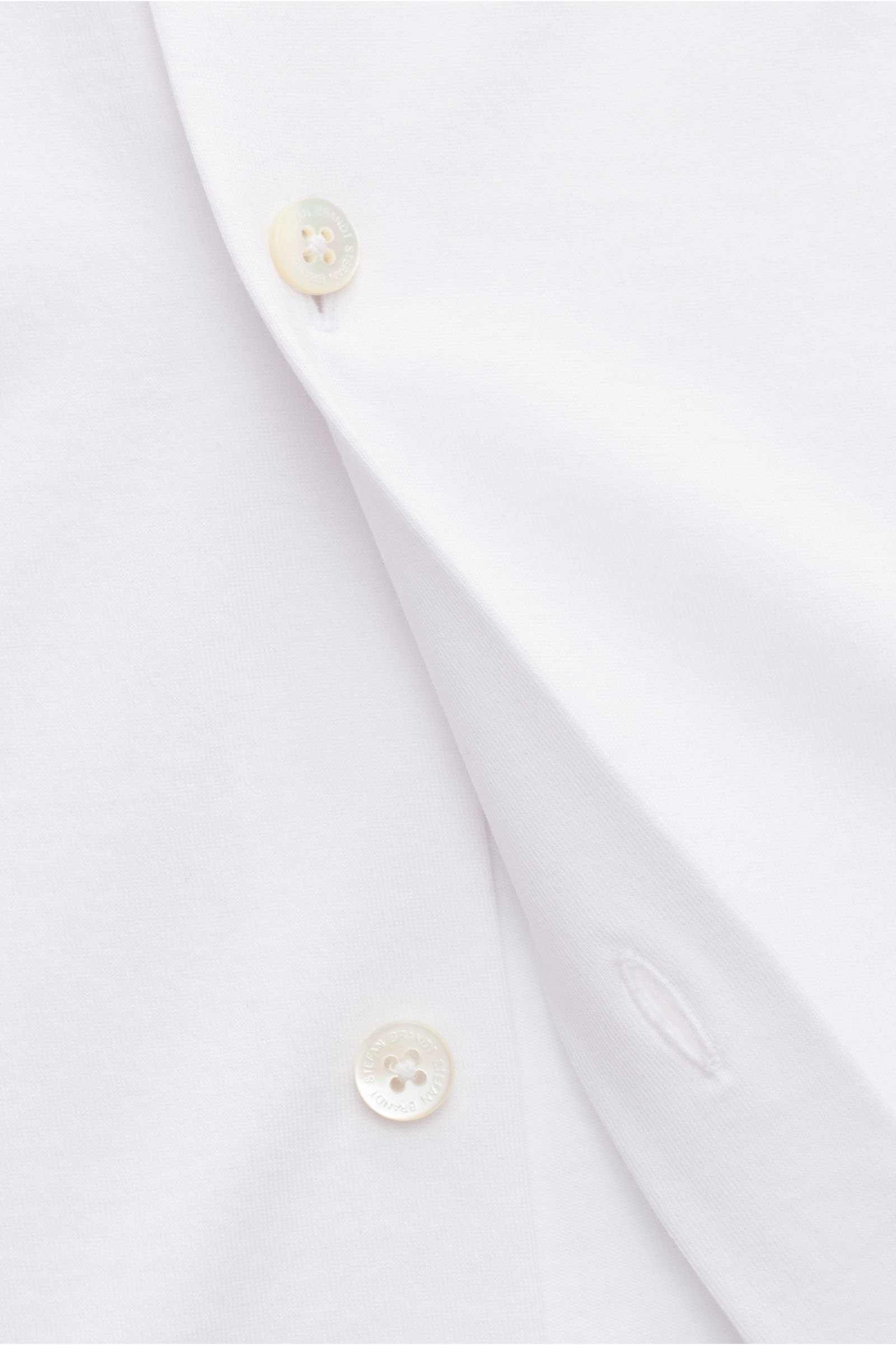 Close-up front view of Stefan Brandt Jersey-Hemd 'Otis' Haifisch-Kragen weiß, showing smooth white Pima cotton jersey fabric, buttons, and buttonholes. Flexibler, geschmeidiger Jersey aus reiner Pima-Baumwolle lässt das cleane Casual Hemd 'Otis' von STEFA