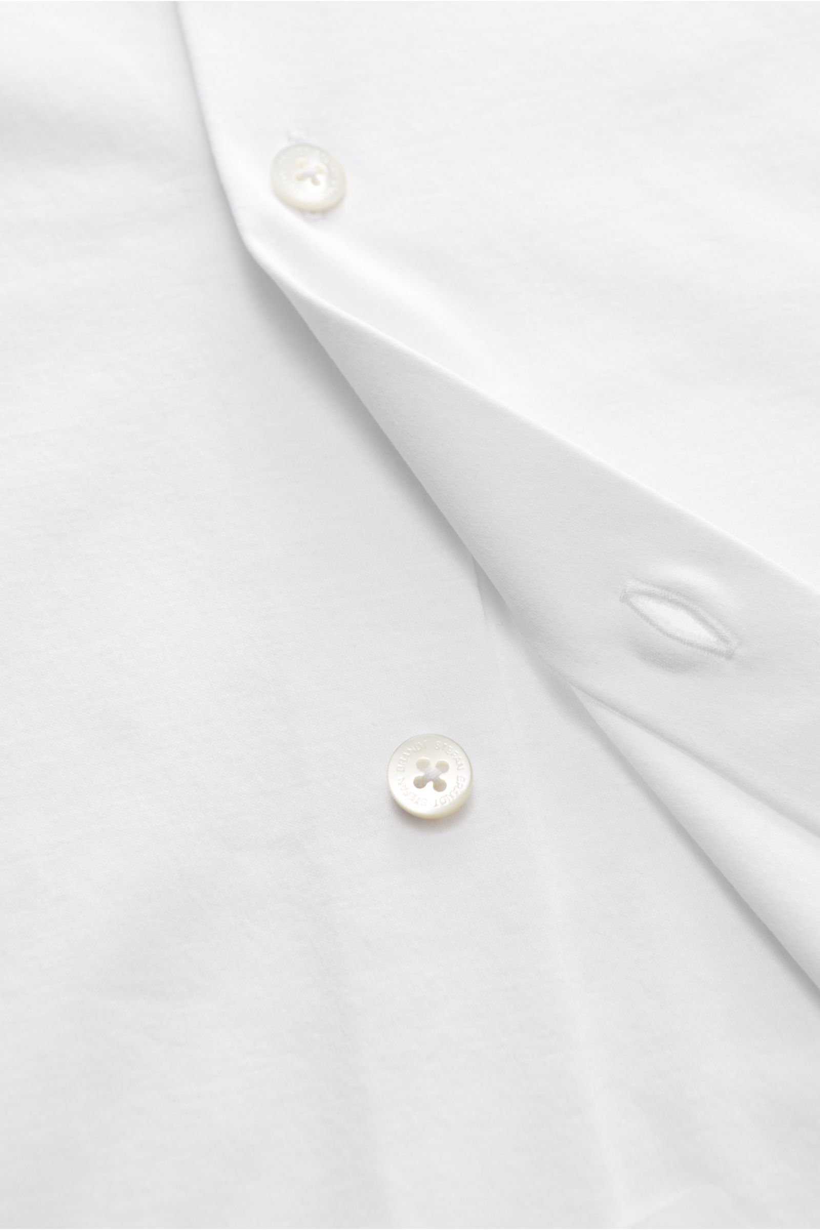 Nahaufnahme von Stefan Brandt Jersey-Hemd 'Otis' Haifisch-Kragen weiß aus weichem Pima-Baumwoll-Jersey, Slim Fit, Perlmuttknöpfe, Haifisch-Kragen, französische Knopfleiste, gerundeter Saum.