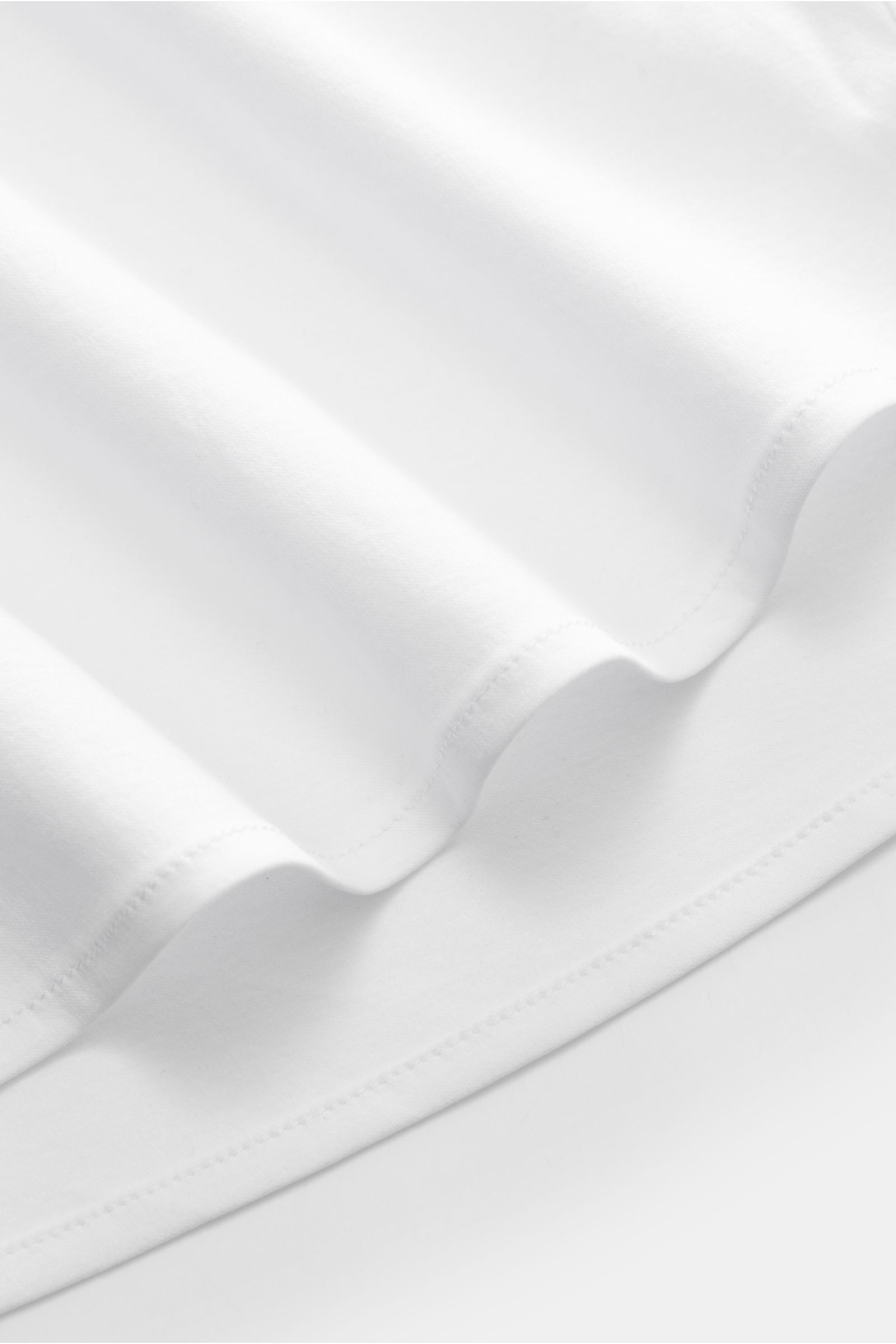 Stefan Brandt Jersey-Hemd 'Otis' Haifisch-Kragen weiß, Slim Fit, aus weichem Pima-Baumwoll-Jersey, Detailaufnahme Saum in Nahaufnahme.