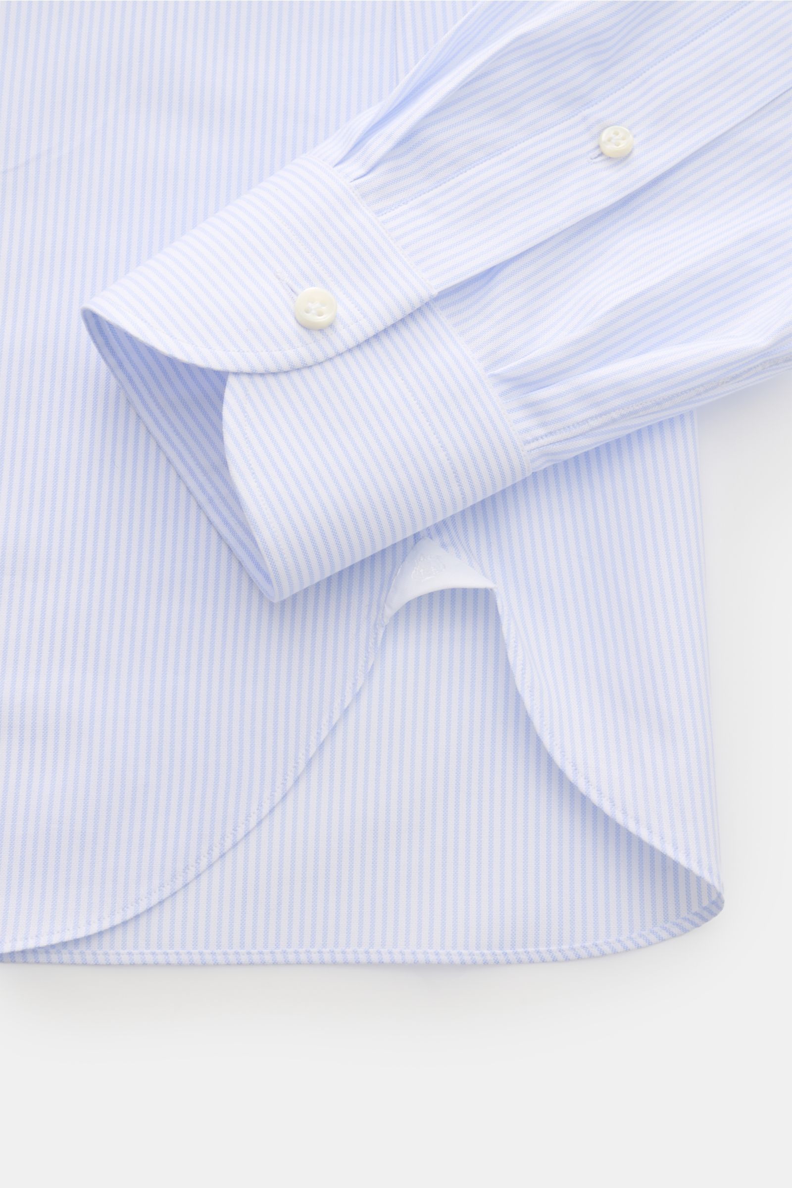 Nahaufnahme des gerundeten Saumverlaufs und der klassischen Sportmanschette des Giampaolo Oxford-Hemd Button-Down-Kragen hellblau/weiß gestreift aus feinem Baumwoll-Oxford mit Slim Fit und rückwärtigen Taillenabnähern.