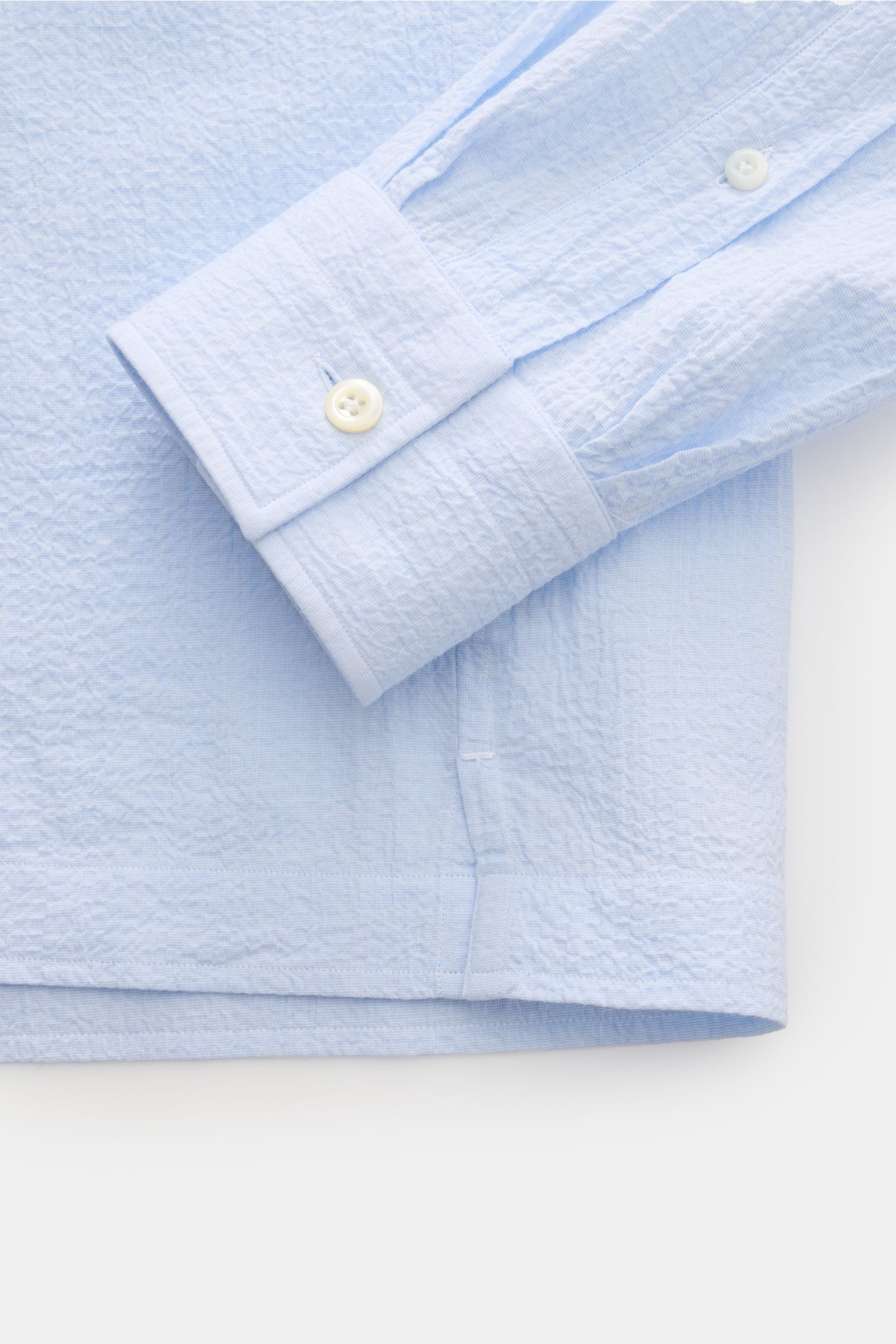 Nahaufnahme des hellblauen Giampaolo Seersucker Popover-Hemd Haifisch-Kragen mit elastischer Baumwolle, sportiver Manschette und kurzem Saumschlitz.