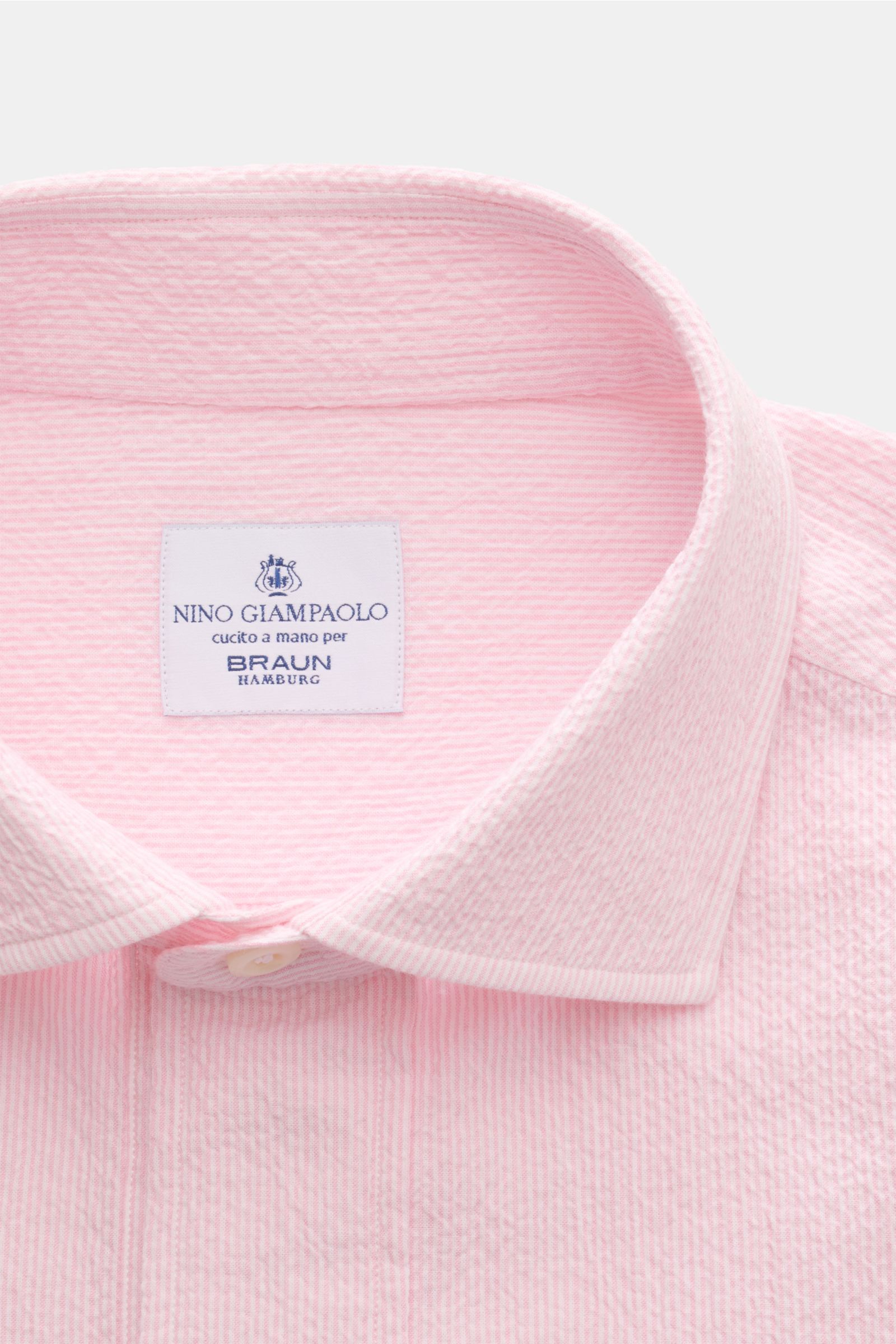 Nahaufnahme von Giampaolo Seersucker Popover-Hemd Haifisch-Kragen rosé, elastische Baumwolle, Seersucker-Struktur, Perlmuttknöpfe, Regular Fit, von oben fotografiert.