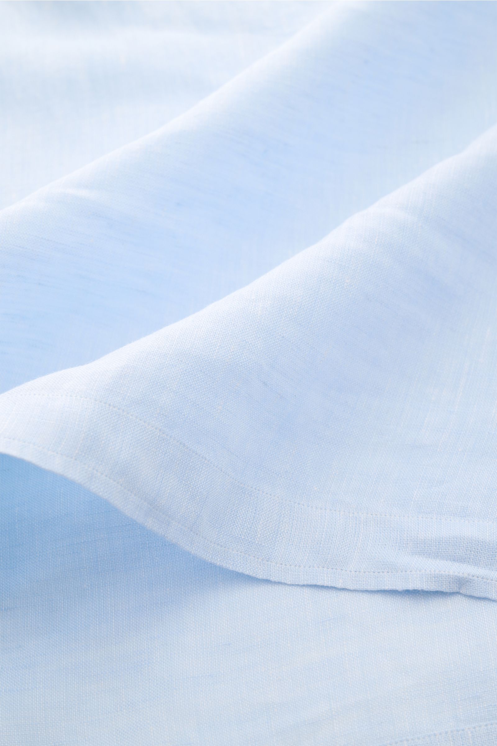 Nahaufnahme des hellblauen Giampaolo Leinen Popover-Hemd Haifisch-Kragen, reine Leinenstruktur, leichter Stoff, gerader Saum mit kurzen Schlitzen.