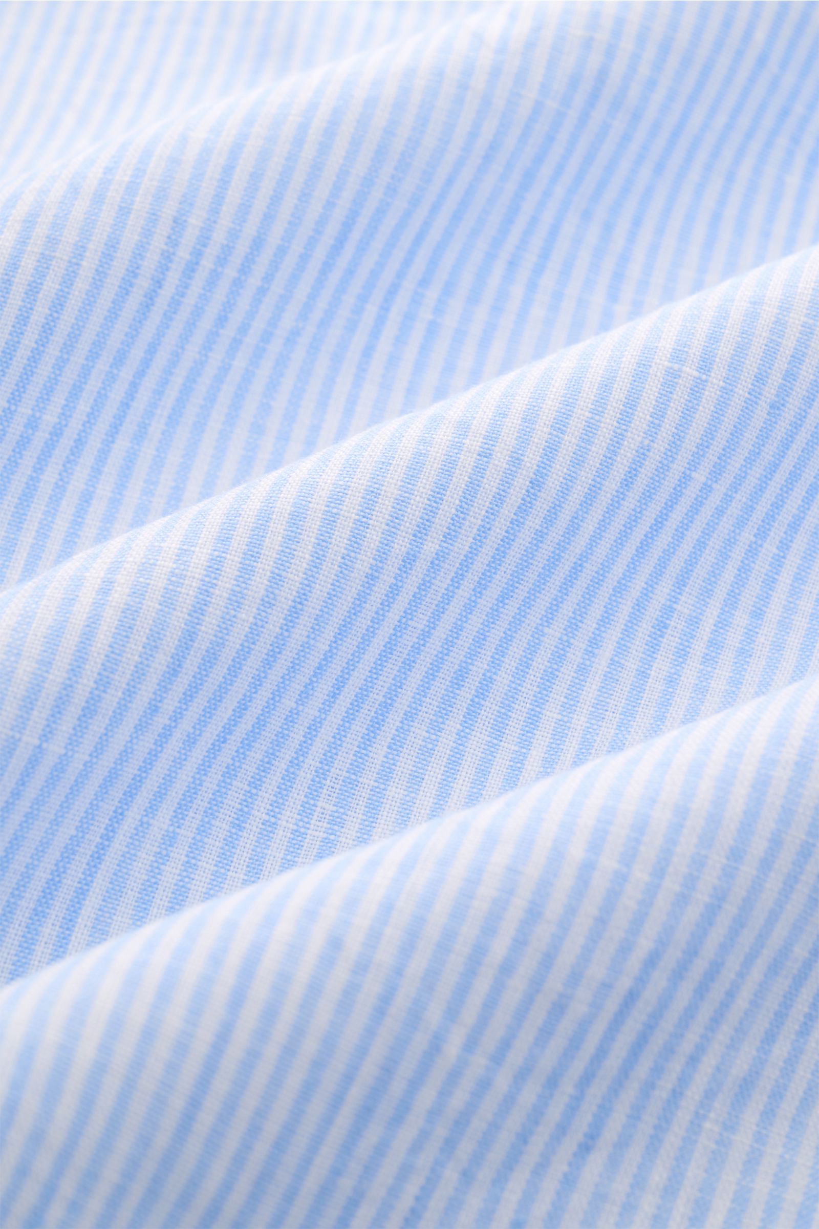 Close-up front view of light blue and white striped fabric of Giampaolo Popover-Leinenhemd Haifisch-Kragen hellblau/weiß gestreift, a breathable linen shirt with canvas weave, slightly textured feel, lightweight quality, regular fit, shark collar, button 