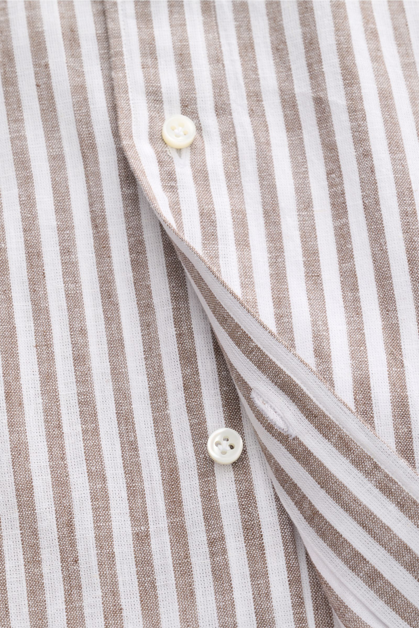 Nahaufnahme aus schräger Perspektive des Giampaolo Casual Hemd Haifisch-Kragen graubraun/weiß gestreift aus leichtem Baumwolle-Leinen-Gewebe mit Slim Fit, aufgesetzter Knopfleiste, klassischer Sportmanschette und gerundetem Saumverlauf.