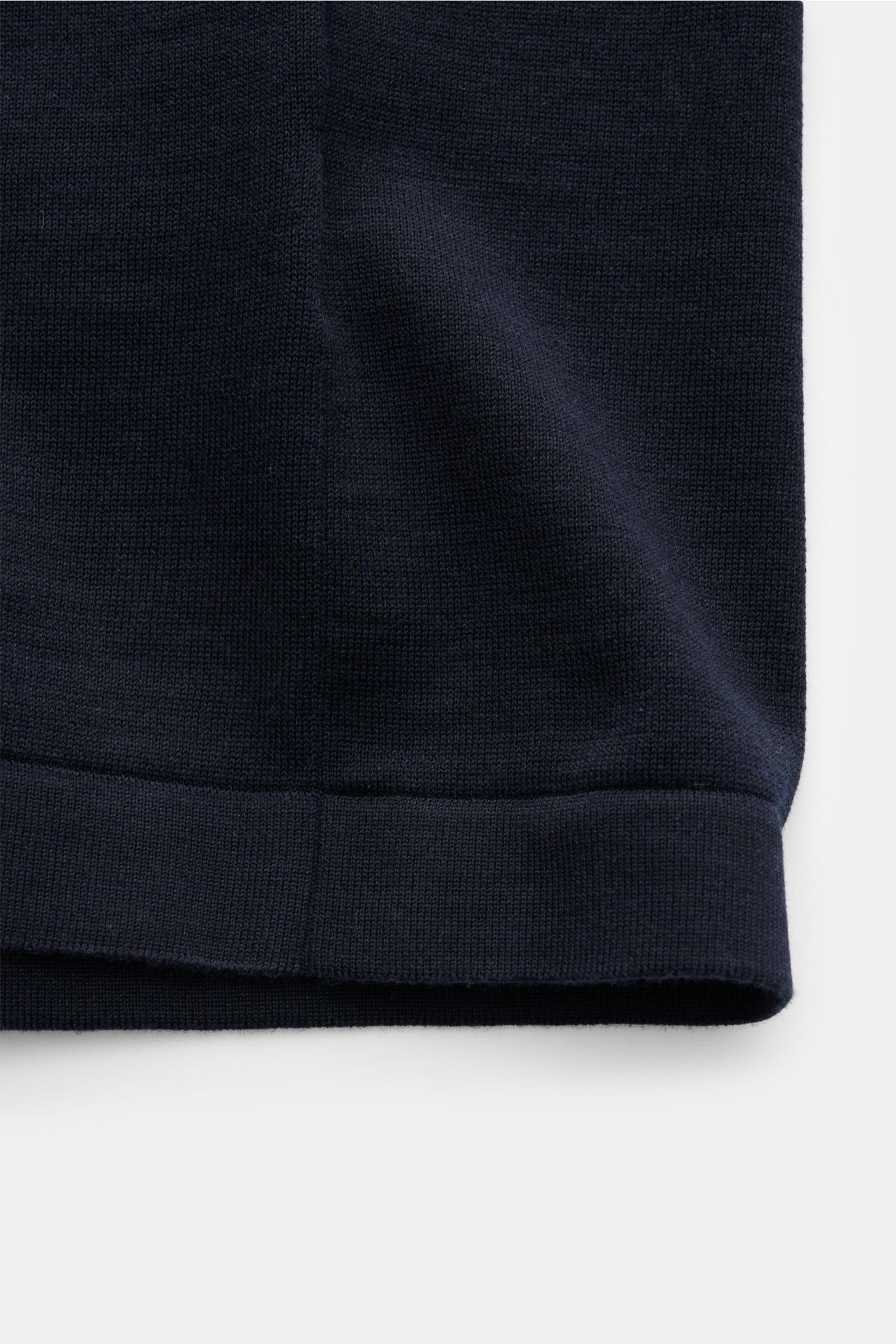 Close-up of the hem of the Della Ciana Strickhemd Kent-Kragen navy, showing fine knit fabric in silk and cotton with a straight hemline and soft texture, photographed from a front perspective. Lässige Alternative zum Businesshemd: Mit diesem gestrickten H